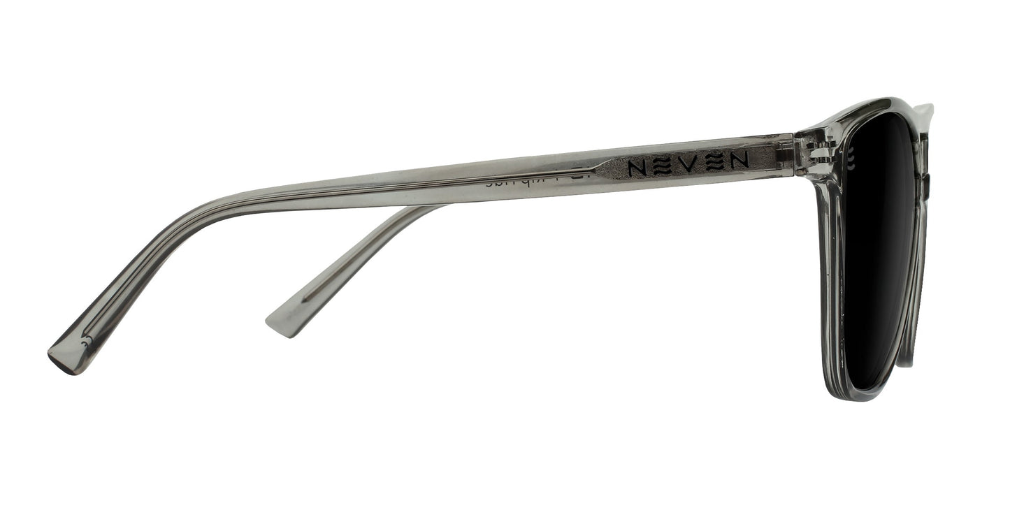 Side view of Rip Tide sunglasses by Neven Eyewear with clear gray plastic frames and black lenses. The straight temple arm displays NEVEN in bold capitals. Enjoy UV400 protection in style, set against a plain white background.