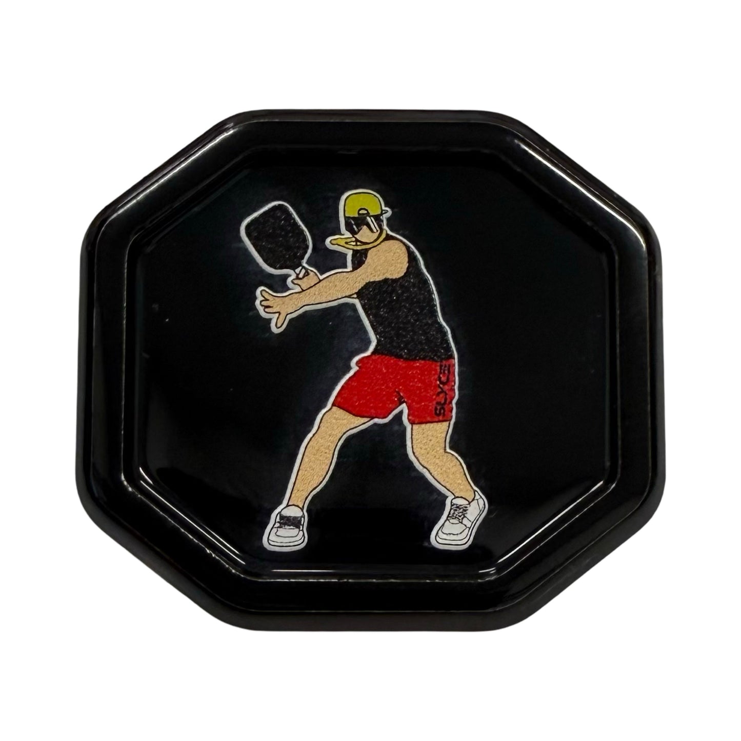 A black octagonal tray shows a stylized figure wearing the Special Edition “Dink Man” SpeedCap by Slyce Sport, swinging a paddle mid-action in a black tank and red shorts on a plain black background.