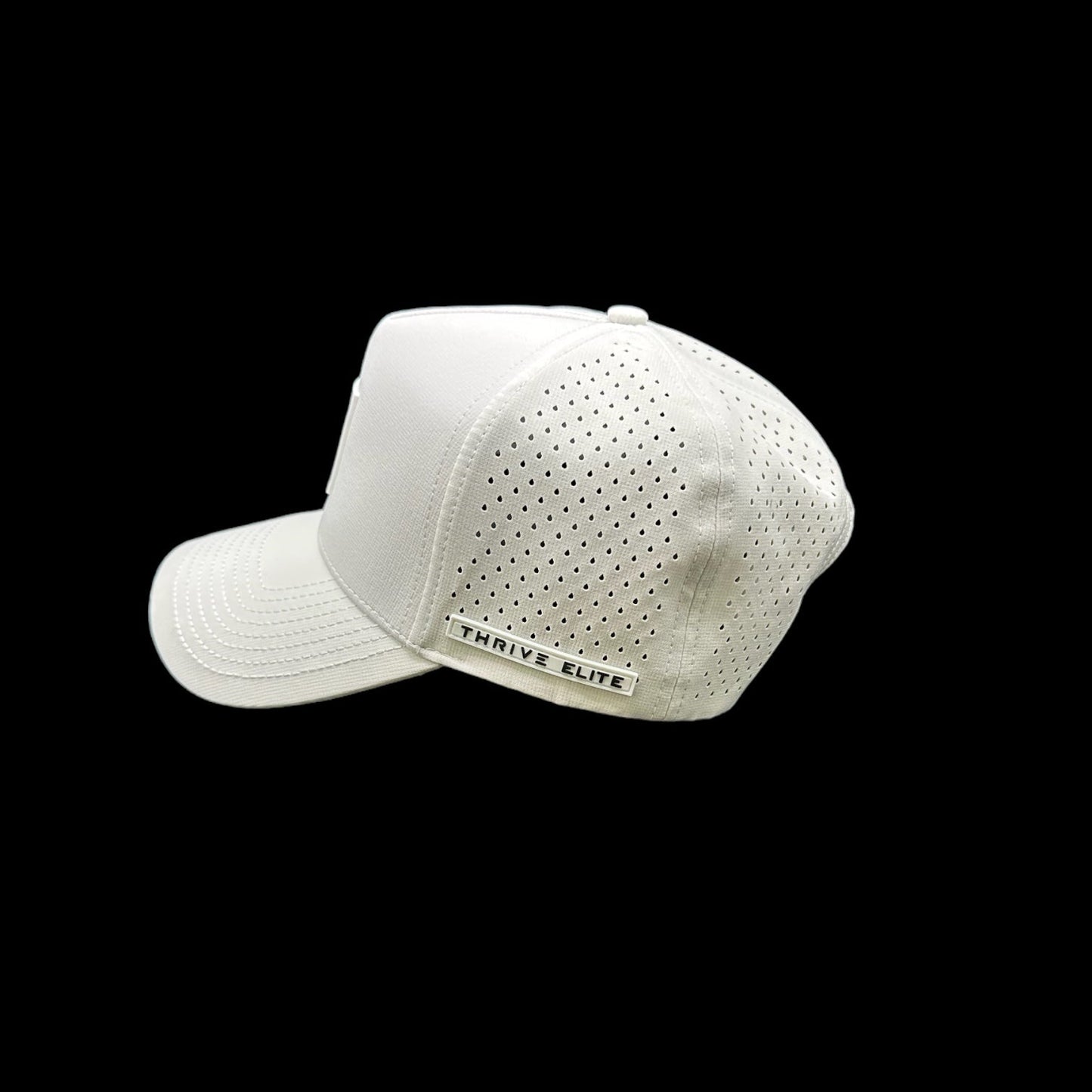 The Thrive Pickleball Thrive Elite Tour Hat features a white solid front, perforated back panel, and a "THRIVE ELITE" label on the back, showcased facing backward left against a black background as luxury performance headwear.