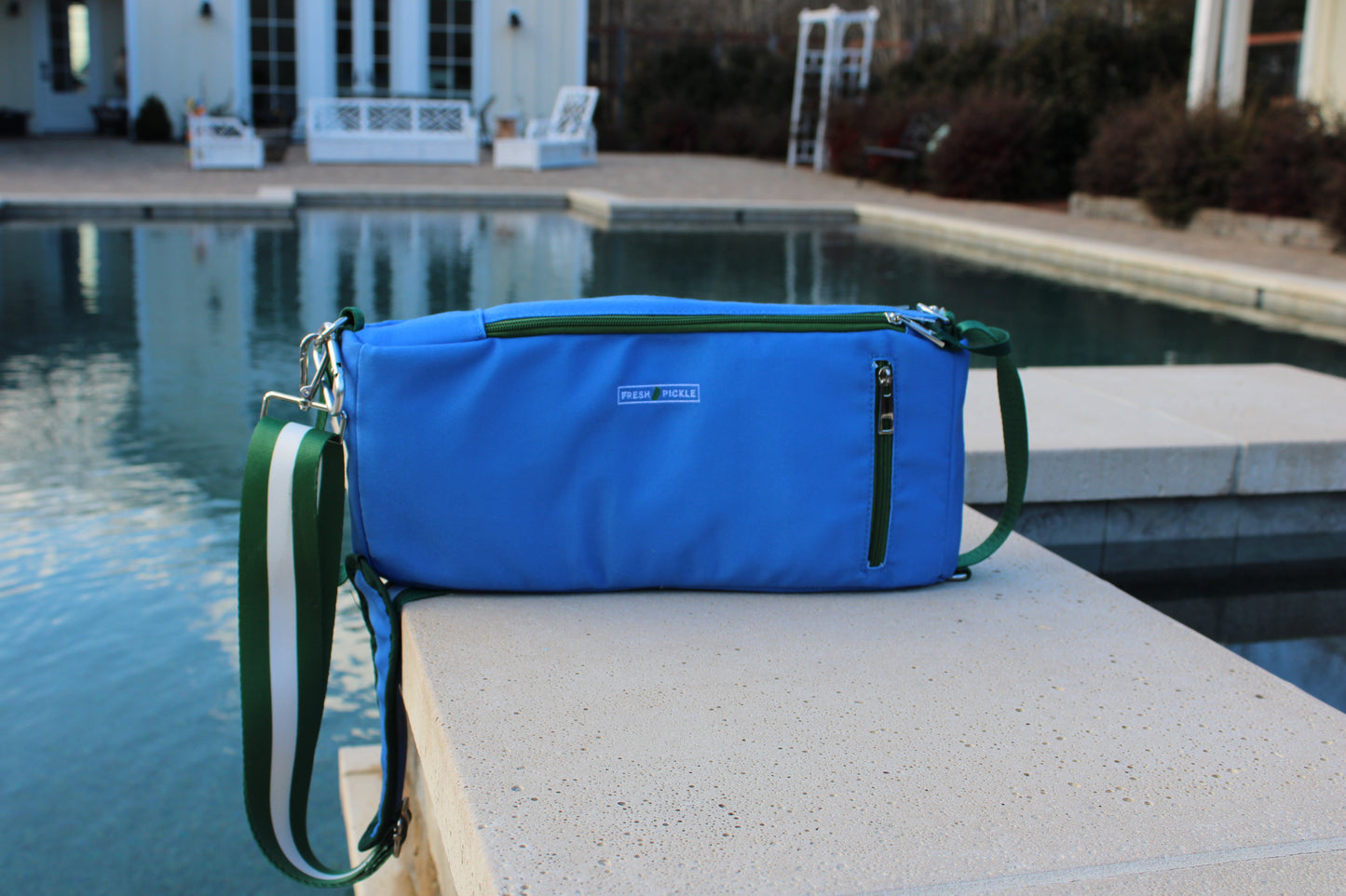 The Fresh Pickle Insulated Cooler Bag sits poolside, keeping your drinks perfectly chilled and your court essentials within reach.