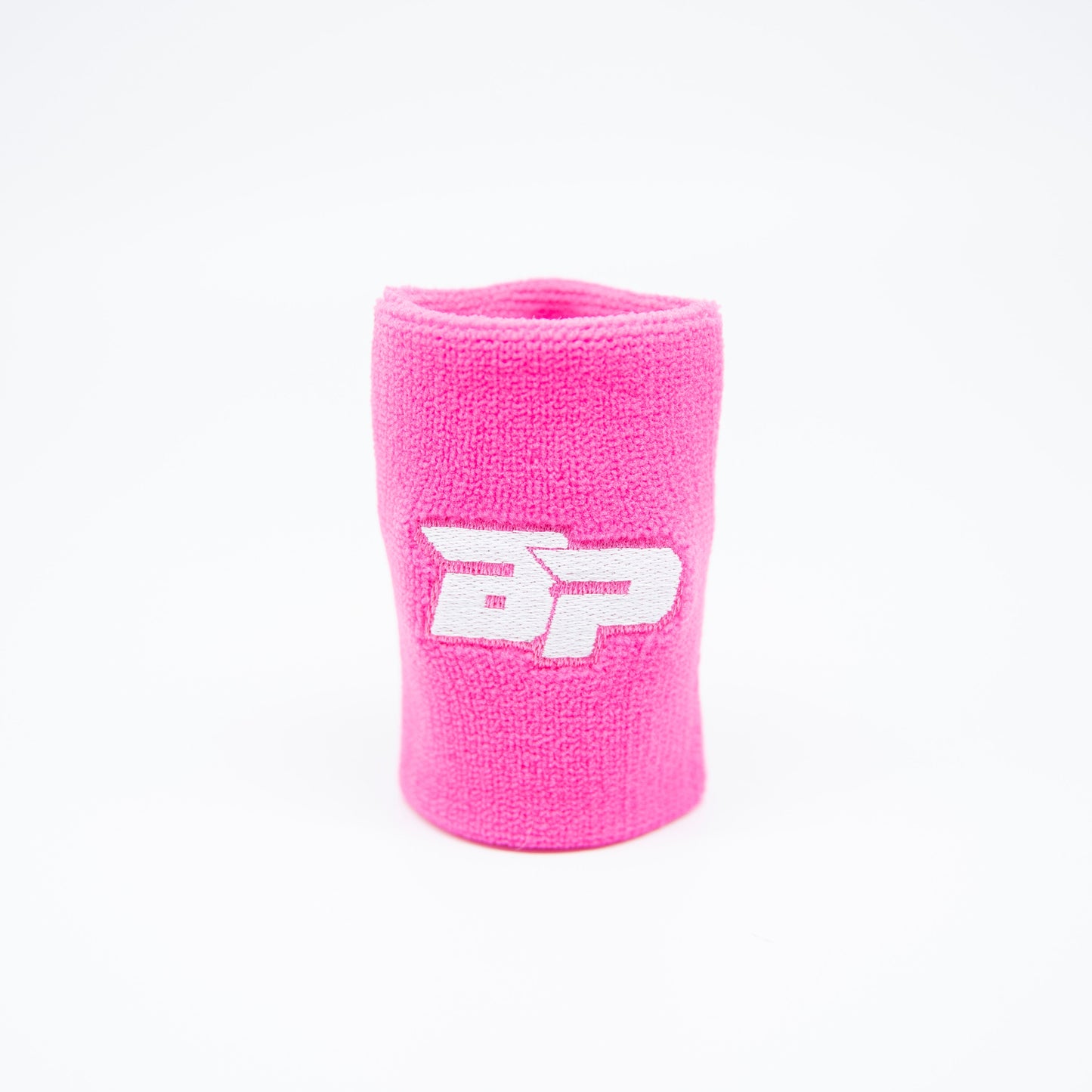 The Bodhi Performance Wristband (1pc) in bright pink stands upright on a white background, featuring a sweat-wicking design and a bold, white embroidered “BP” logo at the center.