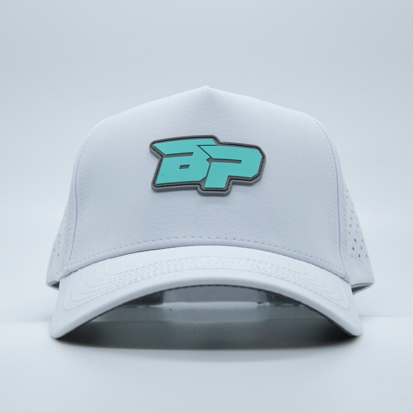 The ICON Snapback by Bodhi Performance is a white performance pickleball hat with a teal and black stylized BP logo, curved brim, ventilation holes, and classic snapback style, shown against a plain light background.