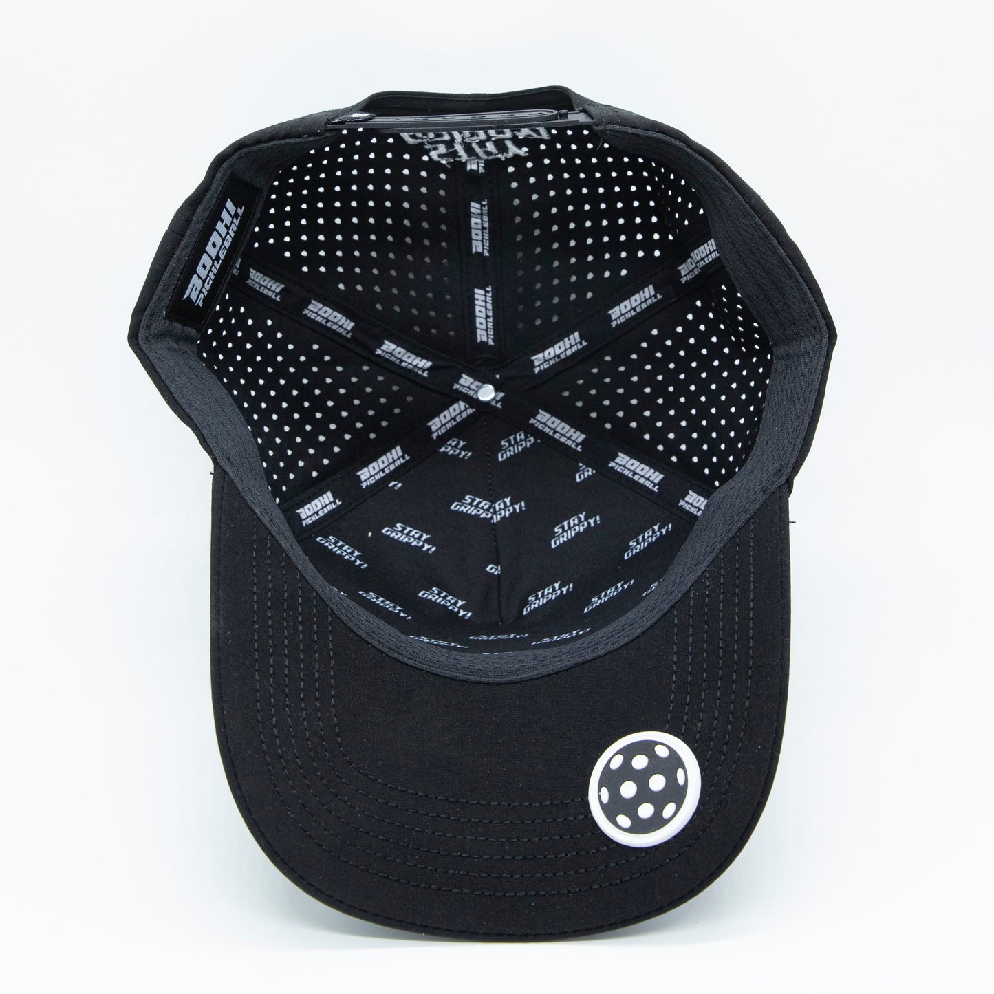 A black Bodhi Performance ICON Snapback cap shown from above, revealing a white polka dot interior, “SPEEDH” and “GATE” printed in white. The curved brim is solid black with visible stitching and a white circular accent near the edge.
