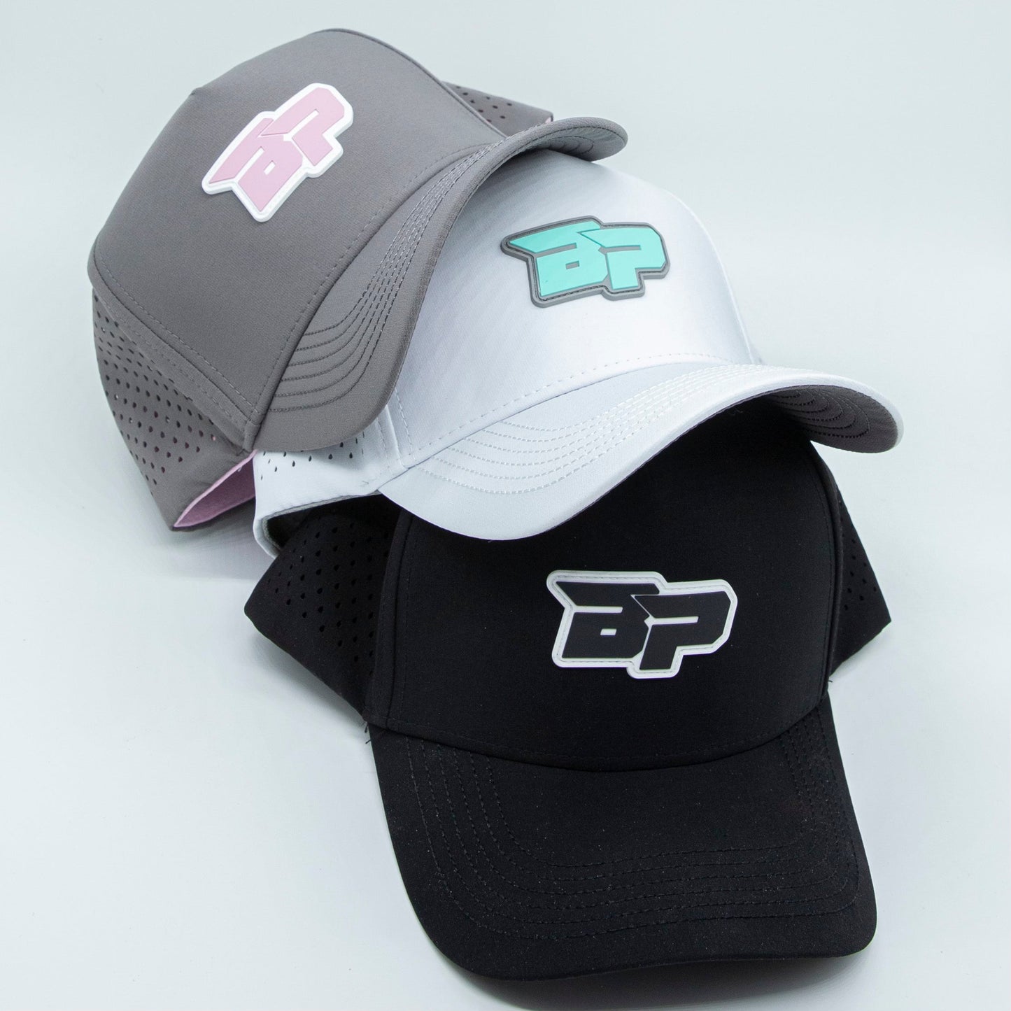 A stack of logo hats, including the Bodhi Performance ICON Snapback and other performance pickleball hat styles.