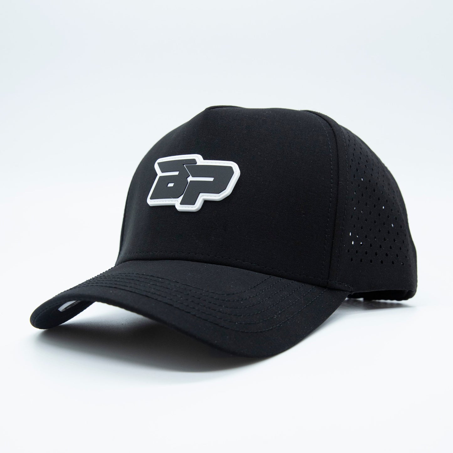 The ICON Snapback by Bodhi Performance is a black pickleball hat with a curved brim, bold white BP logo on the front, and ventilated perforated side panels. Shown angled on a white background.