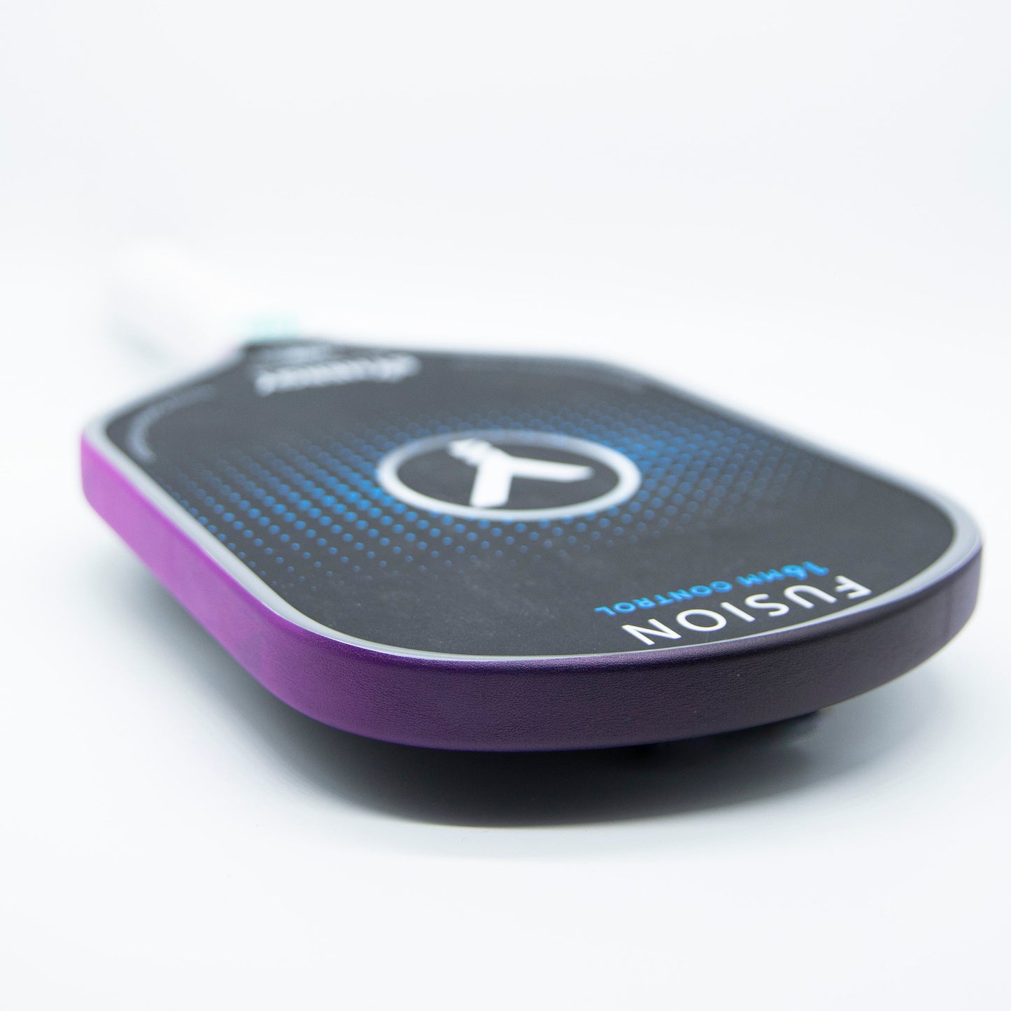 A close-up of Bodhi Performance's Premium Edge Tape - PATTERNS on a pickleball paddle with a black face, blue dots, and "FUSION" in white. The purple tape adds style and protection, making it a durable accessory against a white background.