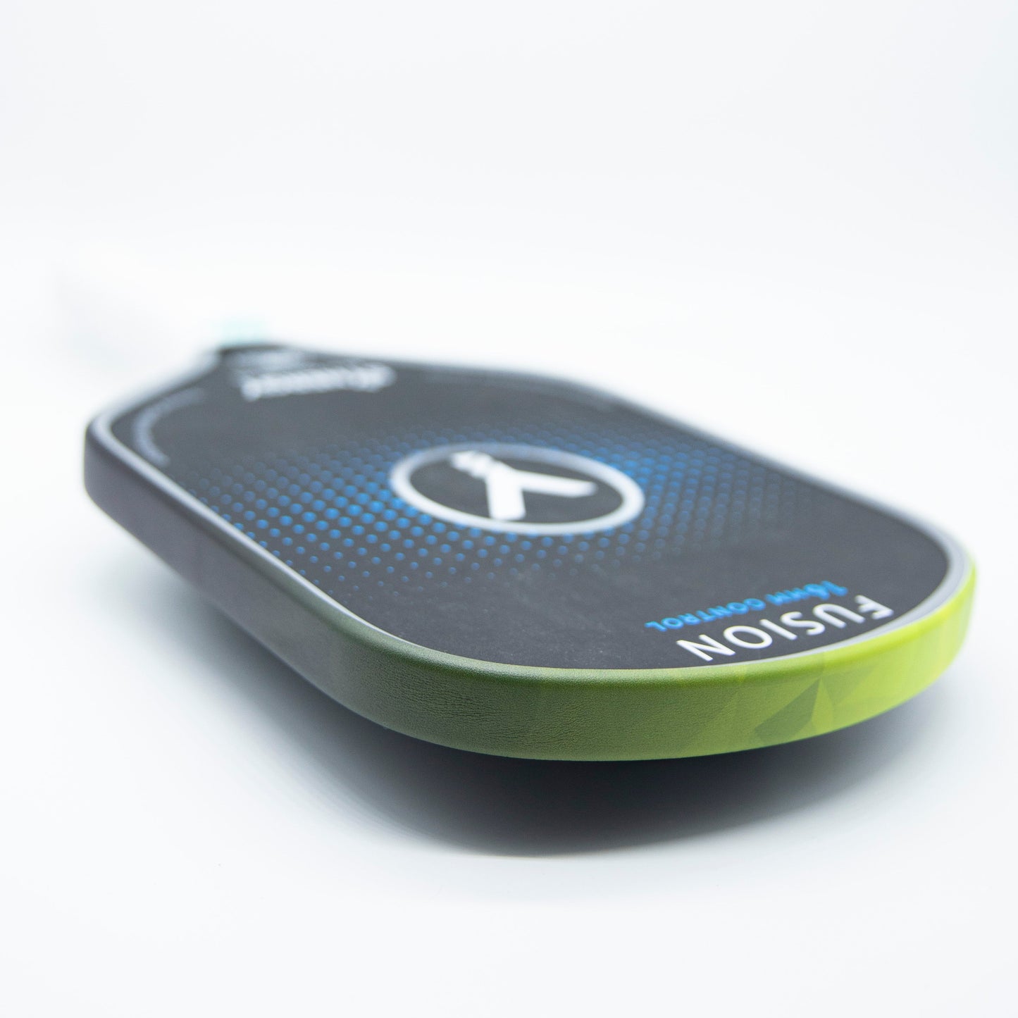 A close-up photo showcases Bodhi Performance’s Premium Edge Tape - PATTERNS in green on a black pickleball paddle, highlighting edge guard protection. The blue circular logo appears at center, with “FUSION” in bold white near the bottom; handle is slightly blurred.