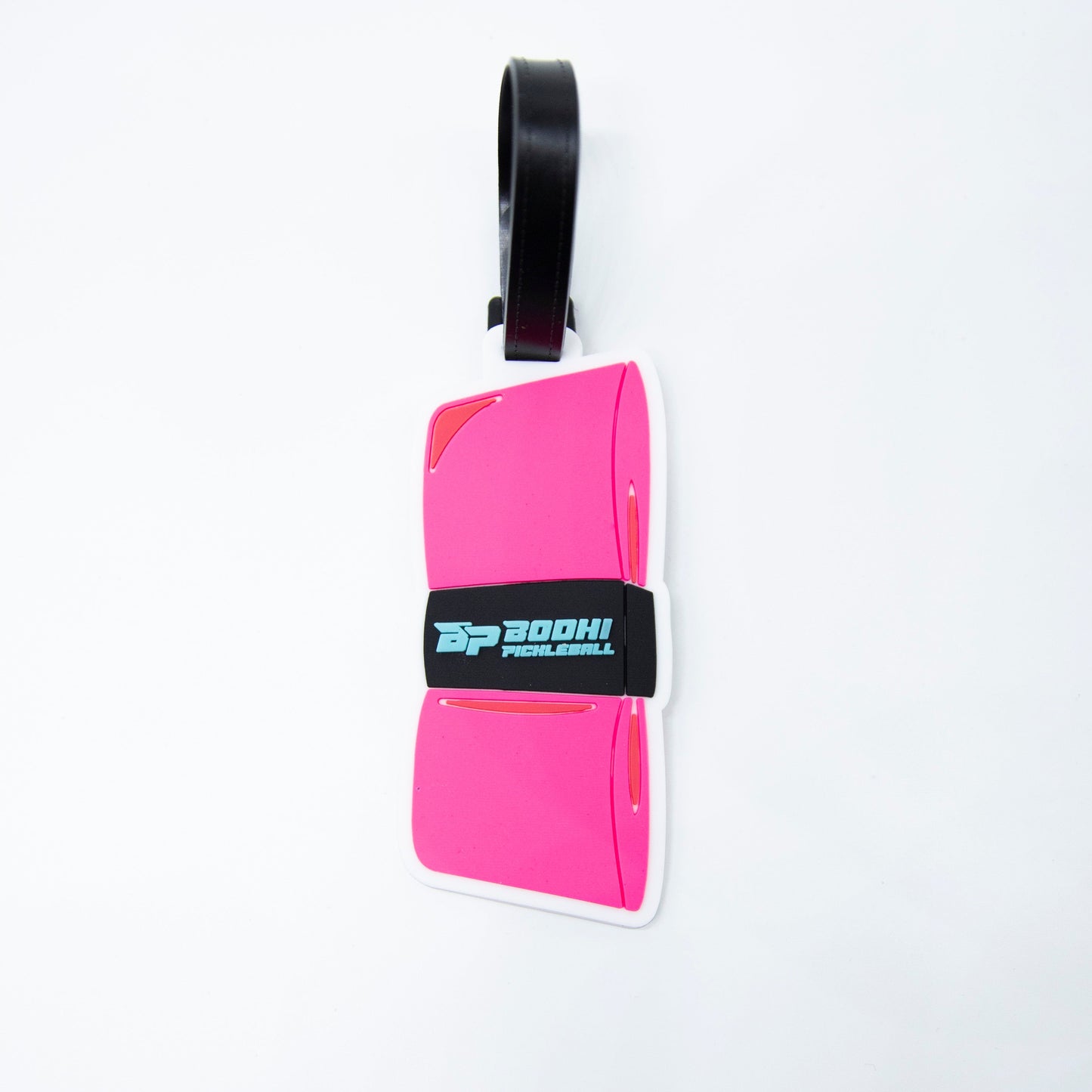 The Bodhi Bag Tag by Bodhi Performance is a pink, rectangular luggage tag with curved edges and a black strap. Perfect for pickleball bags, it features a black band with blue and white “BOOH! PUNCH EMOJI” logo on a plain white background.