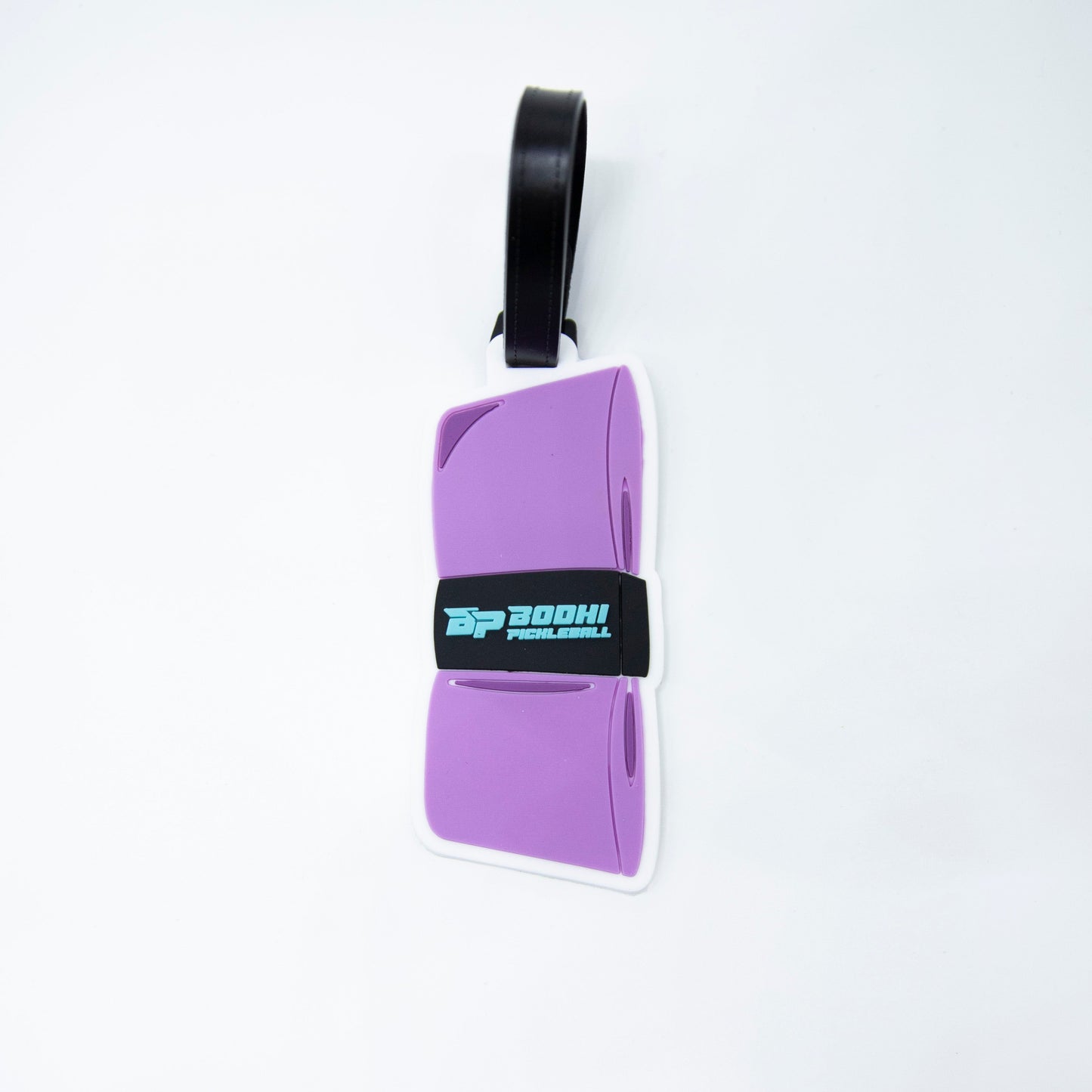 The Bodhi Performance Bodhi Bag Tag is a purple suitcase-shaped tag with a black strap, featuring "DP BOOM! PUNCH GAMING" in blue and white. Perfect for labeling pickleball gear. Background is plain white.