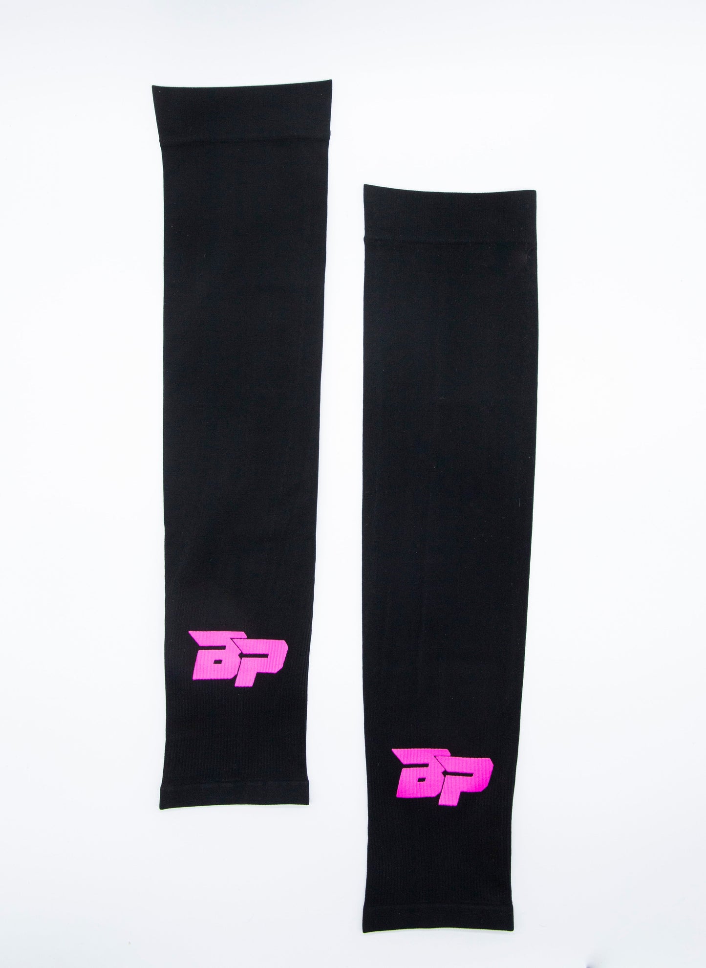 Two black Bodhi Performance Arm Sleeves rest side by side on a white background, each featuring a pink BP logo near one end. The sleeves are simple and unpatterned, designed for UV protection without extra designs.