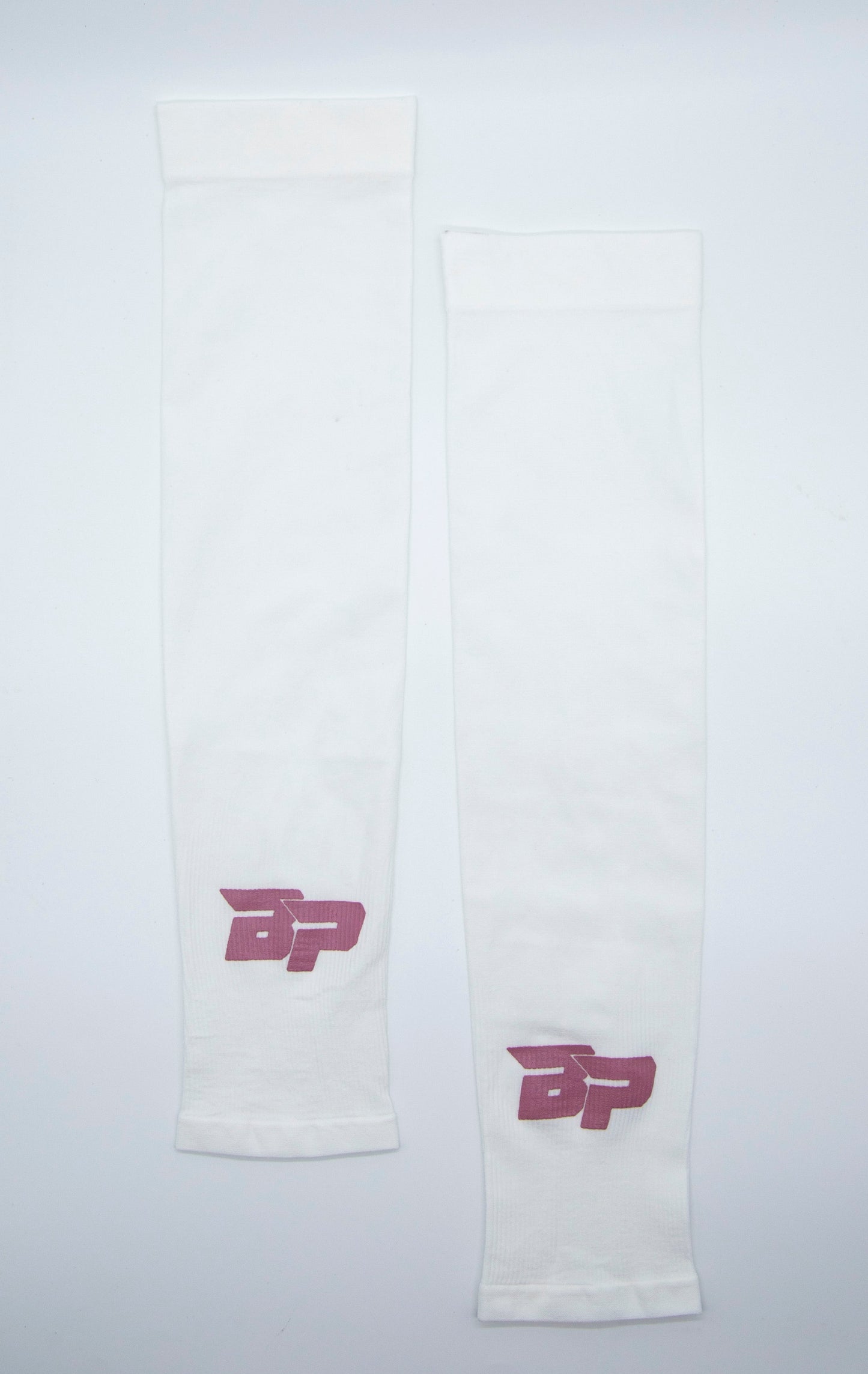 Two white Bodhi Performance Arm Sleeves are laid flat and parallel on a white surface, each featuring a pink BP logo with a swoosh above the B near one end. These sleeves are designed for moisture-wicking performance.