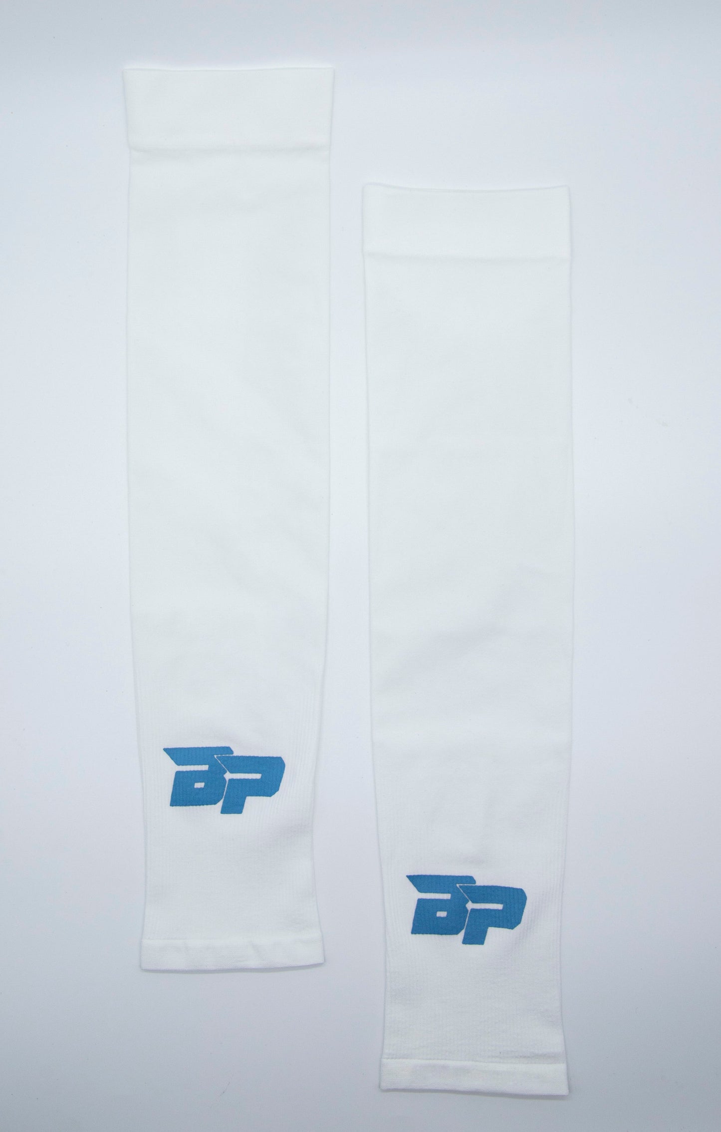 Two white Bodhi Performance Arm Sleeves are laid flat on a white background, each featuring a blue BP logo near the edge. Made from smooth, stretchy material, these sleeves offer moisture-wicking comfort for athletic use.