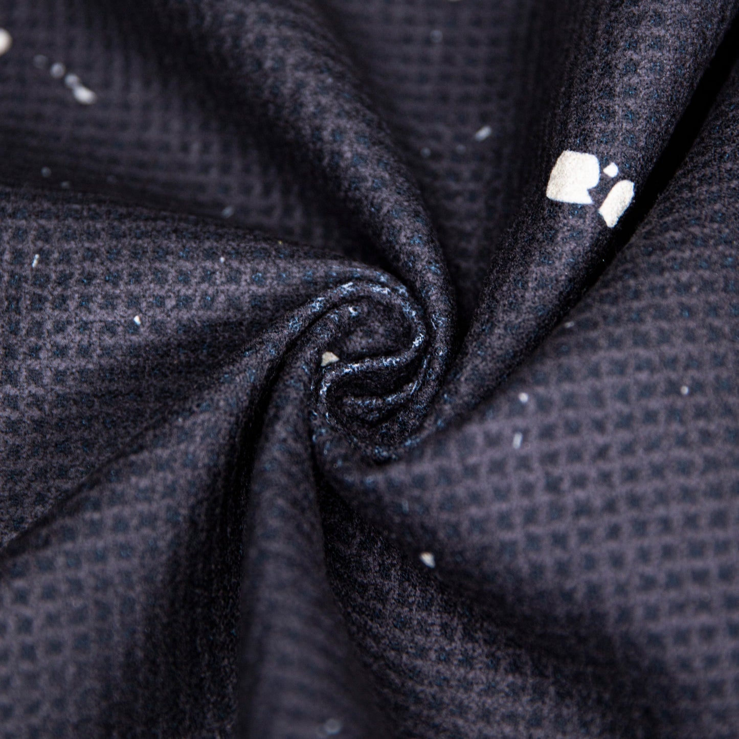 Close-up of the Bodhi Performance Pickleball Towel, featuring dark, textured microfiber with a subtle grid pattern and small white specks. Its slightly worn look makes it perfect for use as a pickleball accessory.