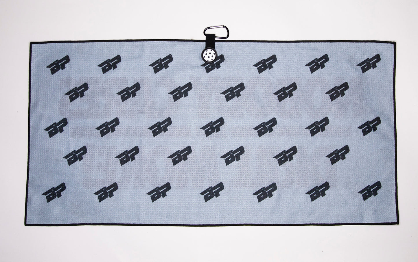 The Bodhi Performance Pickleball Towel is a rectangular gray microfiber towel with a black border and repeating BP logo, featuring a top-center carabiner clip for easy hanging or carrying.