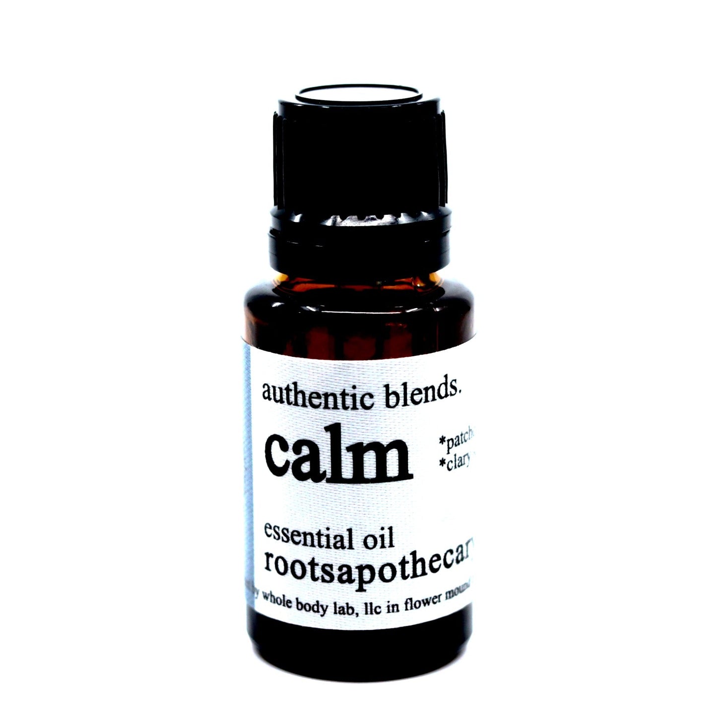 A small amber glass bottle with a black cap labeled "calm essential oil blend" by Roots Apothecary, featuring organic essential oils. The white label with black text contrasts against a white background.