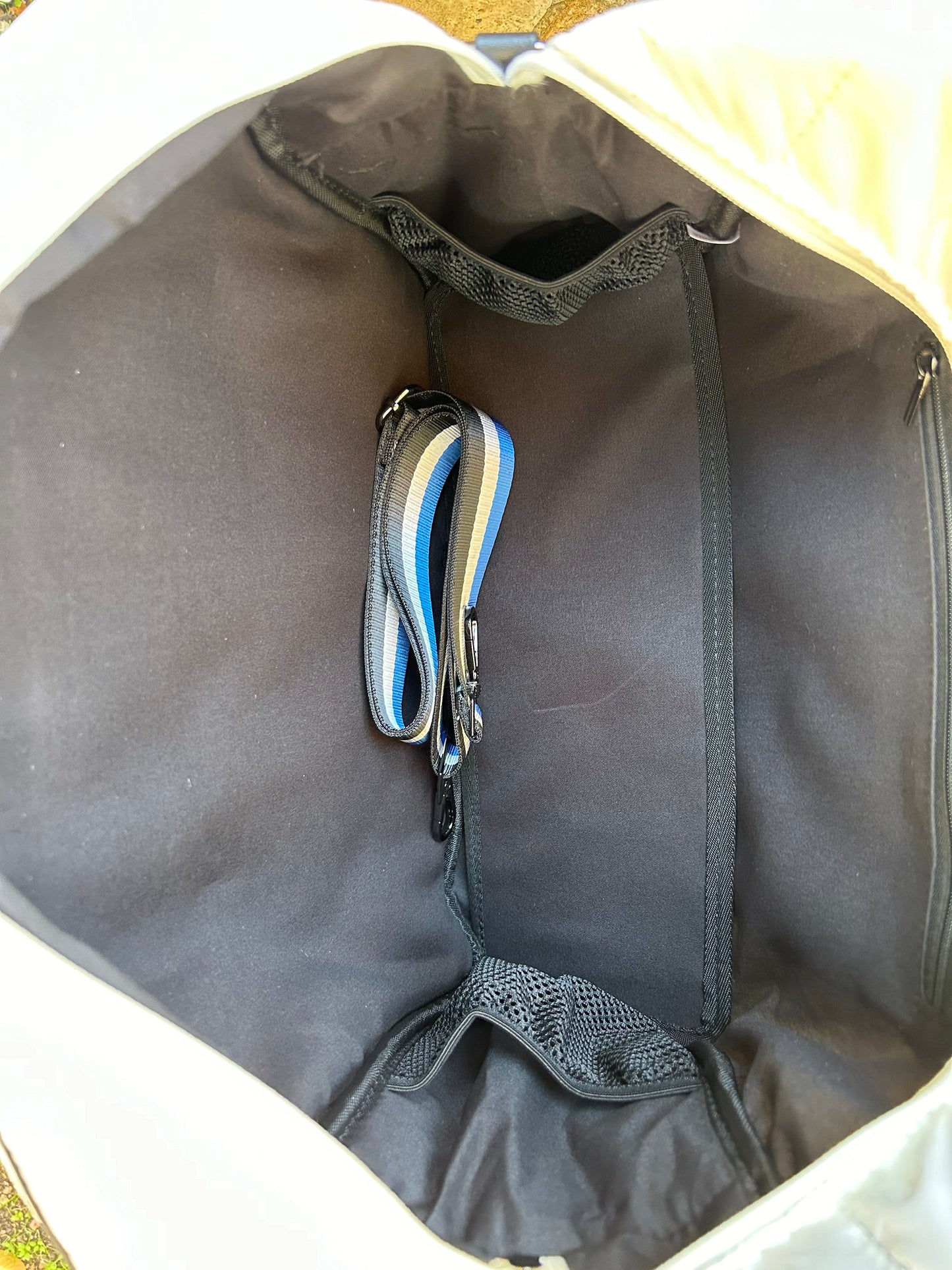 A look inside the Runway Athletics Quilted Puffer Pickleball Tote - White reveals a roomy, sporty interior with mesh side pockets and two fabric key straps (blue and gray) secured to a center metal clip—perfect for all your pickleball essentials.