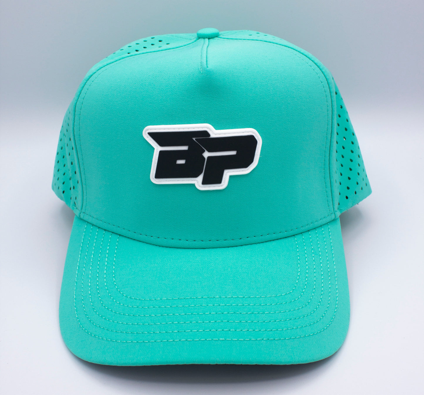 The Bodhi Performance ICON Snapback is a teal pickleball hat with a black and white BP logo, perforated side panels for ventilation, visible stitching on the brim, and set against a plain light gray background.