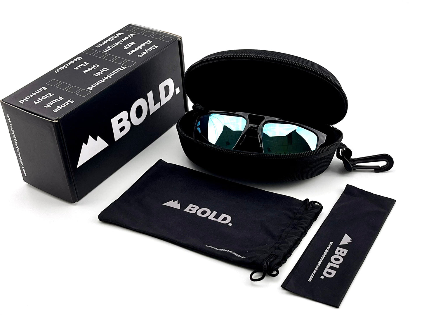 A pair of BOLD Wildhorse Performance Sunglasses by boldouterwear rests in an open black zippered case, with a branded box, drawstring pouch, and cleaning cloth—each black with white logos—arranged neatly on a white surface.