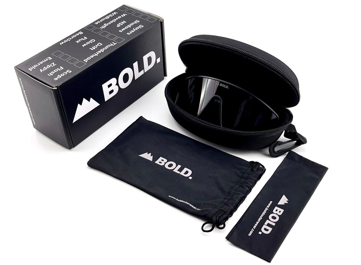 The BOLD NSP Performance Sunglasses by boldouterwear are displayed in a hard zippered case with “BOLD” branding, alongside a matching drawstring pouch and microfiber cloth, all set on white—ideal eyewear for MTB, ski, or lifestyle use and smaller faces.