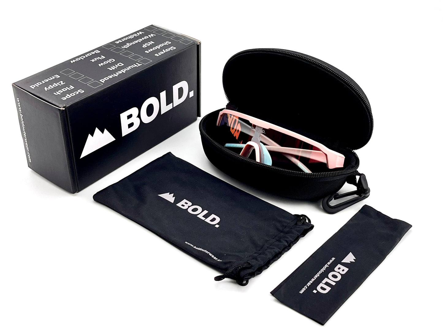 A pair of pink BOLD Zippy Photochromic Sunglasses by boldouterwear rests in a black zippered case, alongside a black “BOLD.” box and two branded drawstring pouches, all displayed on a clean white background.
