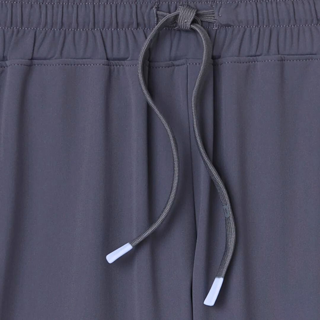 Close-up of the Kelter Short by Playly Store shows a gray elastic waistband with matching drawstrings featuring white plastic tips. The SofKnit fabric looks soft and smooth, promising all-day comfort for men.