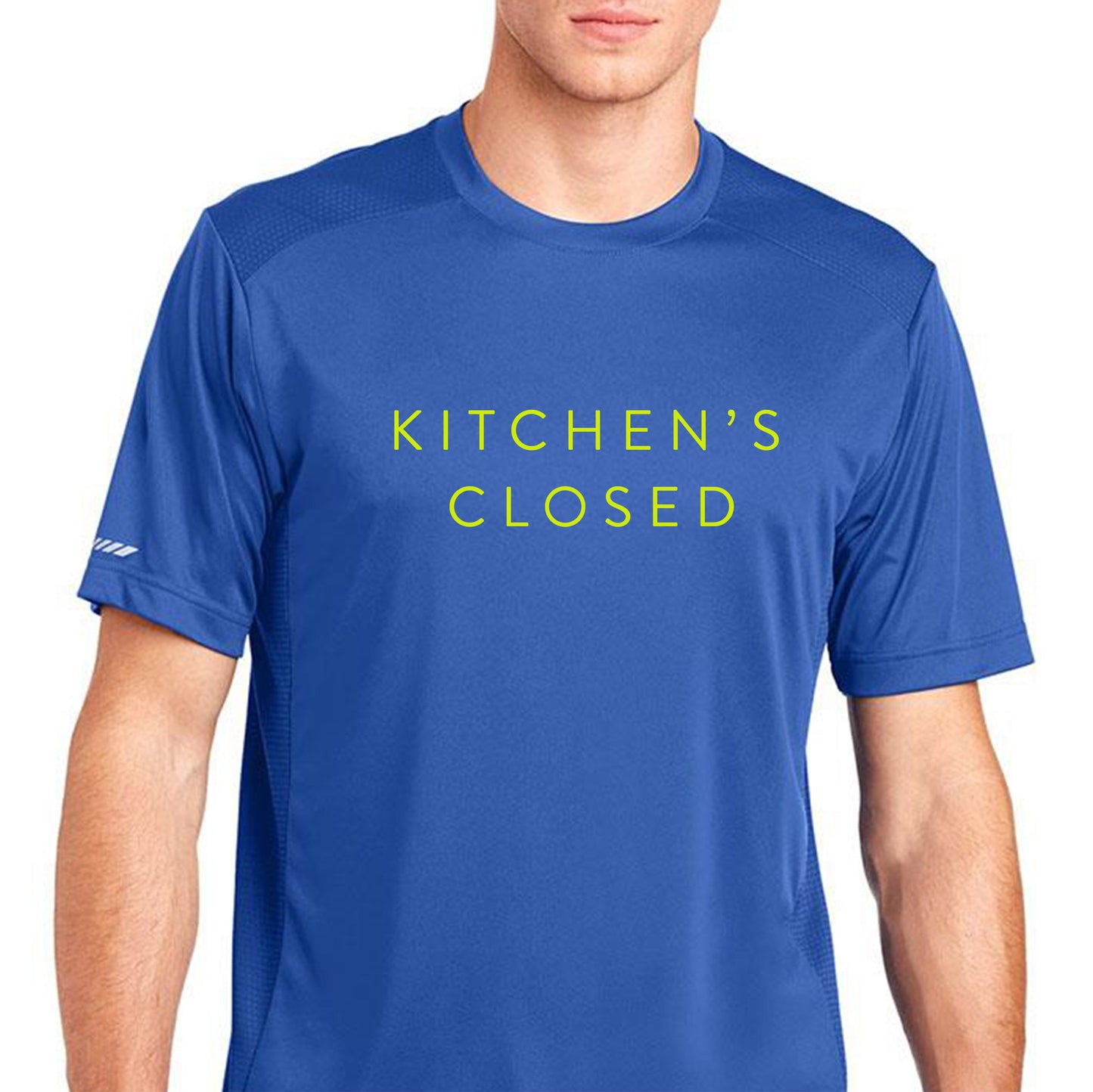 A man wears the Swinton Pickleball Men's Kitchen's Closed Performance Shirt in royal blue, featuring “KITCHEN’S CLOSED” in yellow. This moisture-wicking athletic shirt keeps you cool on and off the pickleball court against a plain white background.