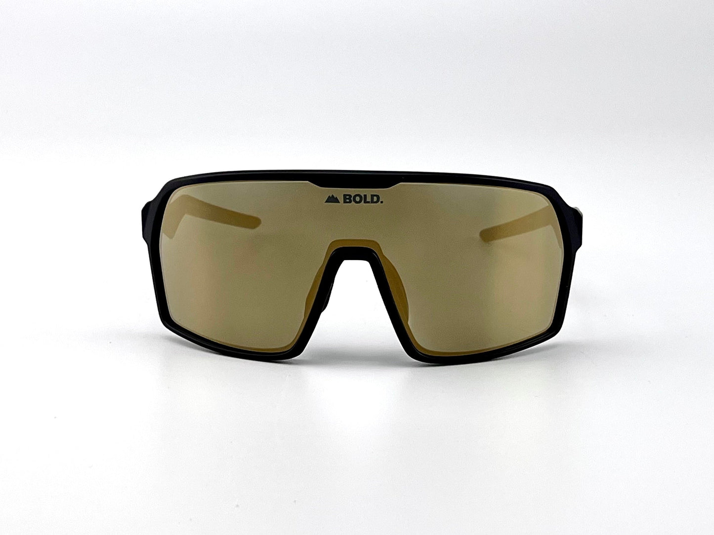 The BOLD Glow Photochromic Sunglasses by boldouterwear feature large gold-tinted wraparound lenses and a black frame. "BOLD." is printed above the nose bridge. Shown against a plain white background, ideal for MTB, ski, and lifestyle use.