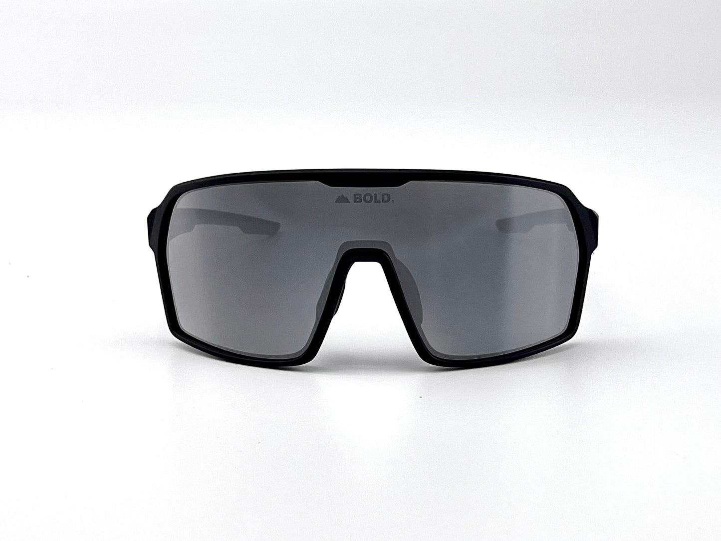 The BOLD Drift Photochromic Sunglasses by boldouterwear feature a large, single mirrored lens and black frame. "BOLD." is printed at the top center, with a plain white background highlighting these modern MTB, ski & lifestyle sunglasses.