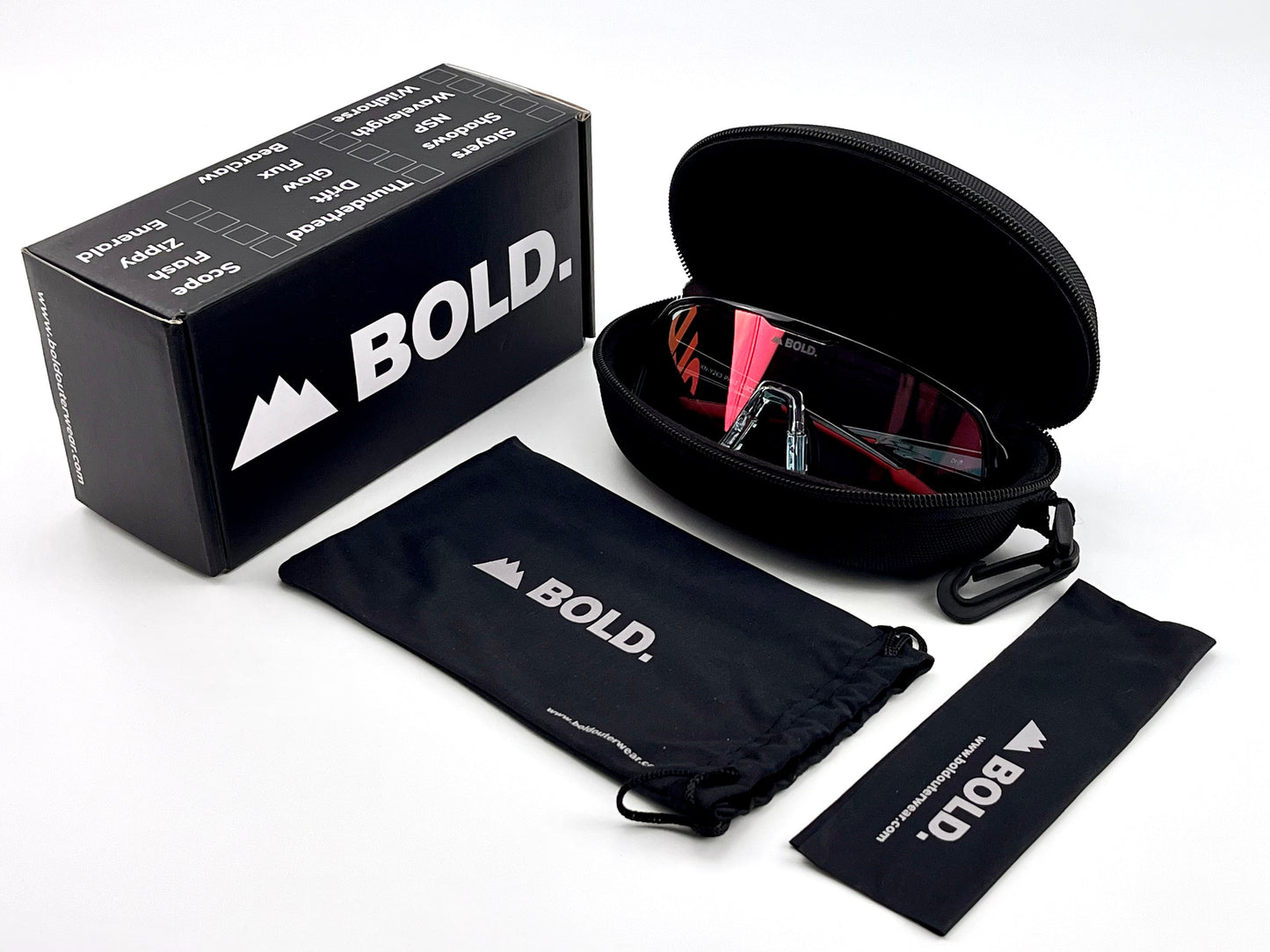 A black boldouterwear case is open, showing pink-lensed BOLD Drift Photochromic Sunglasses—MTB, Ski & Lifestyle Eyewear. A branded pouch, lens cloth, and sleek box are nearby, all set against a white background.