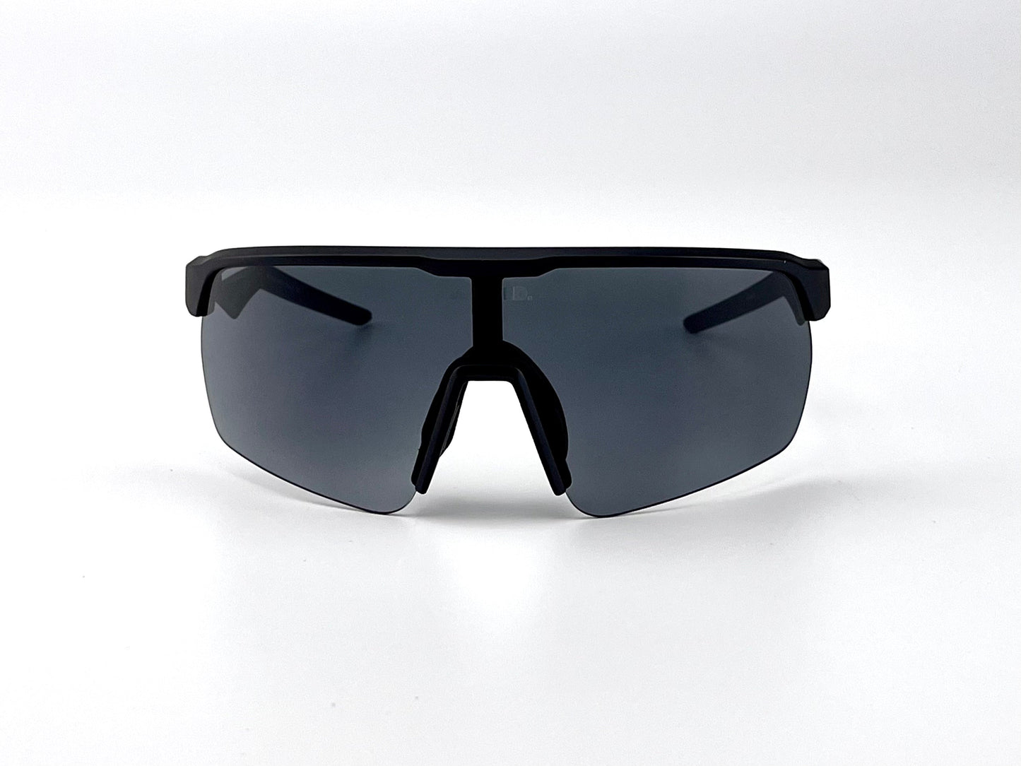 The BOLD Flash Photochromic Sunglasses by boldouterwear, with a sleek wraparound design and a single dark lens, rest on a white surface—perfect for MTB, ski, or lifestyle use.
