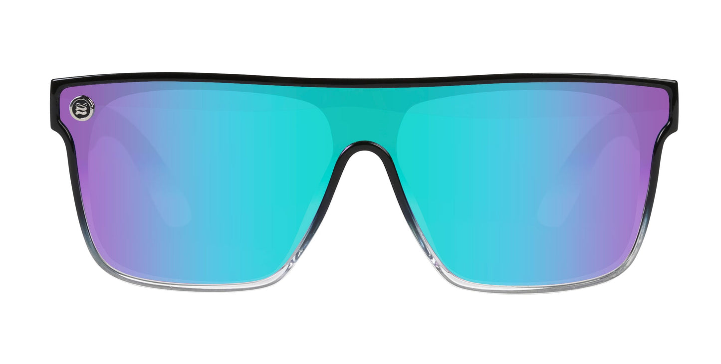 Neven Eyewear’s Nomads XL feature a bold, glossy black rectangular frame with oversized, polarized lenses shifting from teal to purple. UV protection and a subtle silver emblem accent the upper left corner.