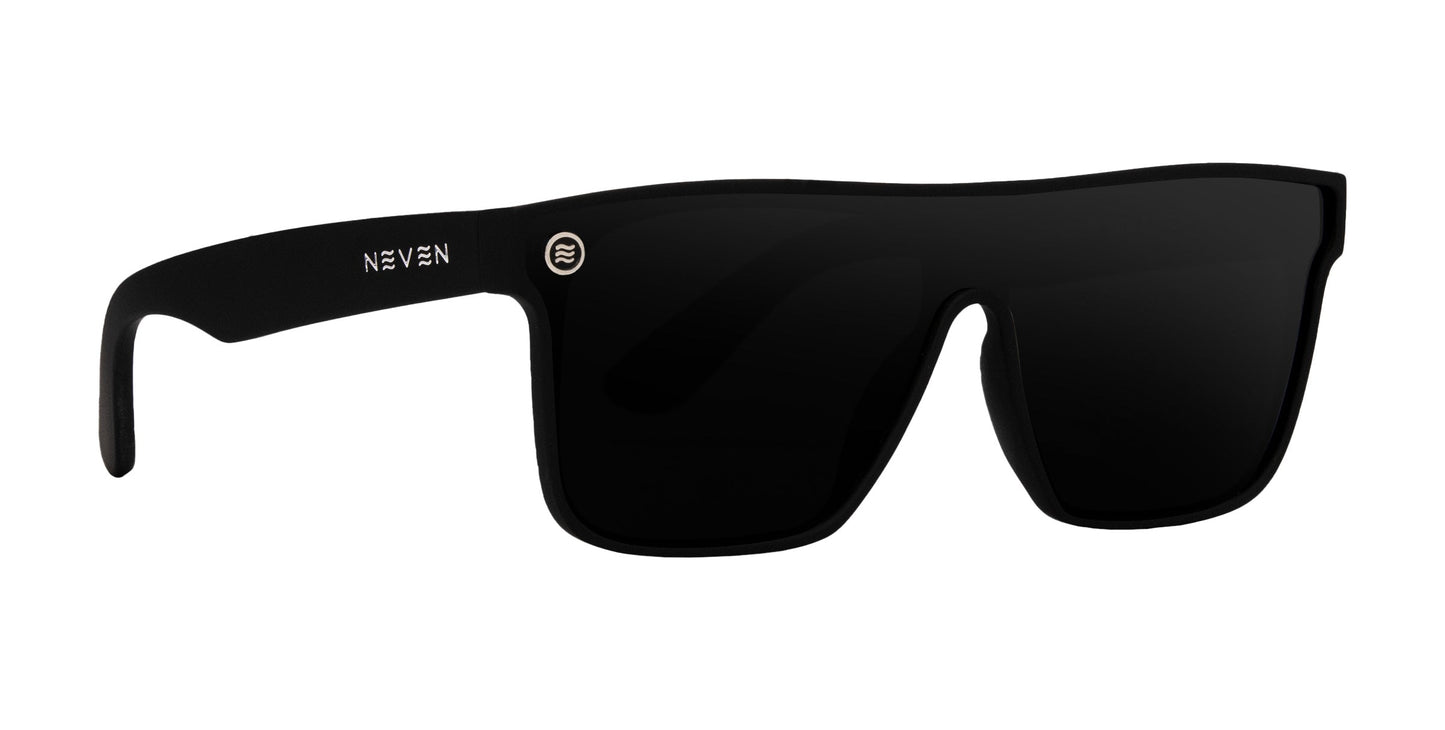 Bold XL by Neven Eyewear are black, rectangular oversized sunglasses with thick frames. The left arm has "NEVEN" in white and a silver emblem at the hinge. Dark lenses provide UV protection for stylish daily wear.