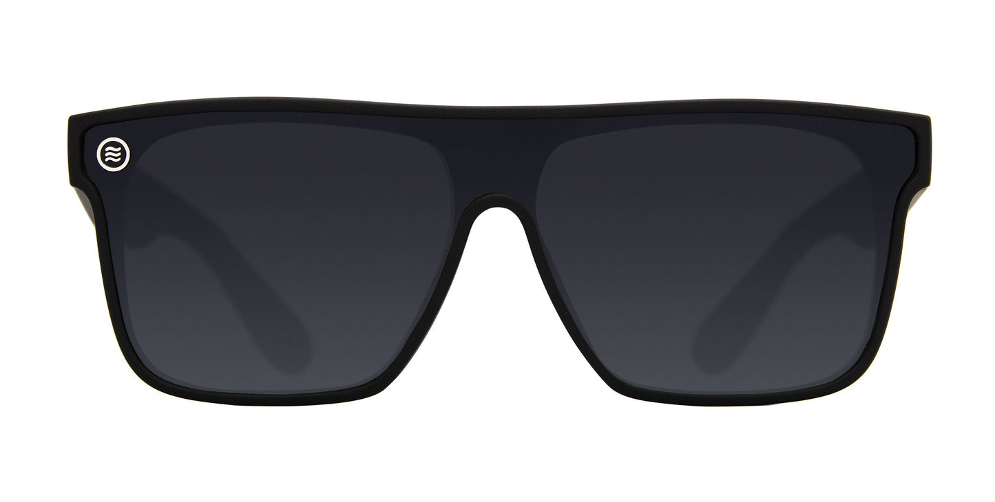 The Neven Eyewear Bold sunglasses feature thick black frames, dark polarized UV400 lenses, and a circular silver emblem with a wavy line on the upper left frame corner. The product is displayed against a plain white background.