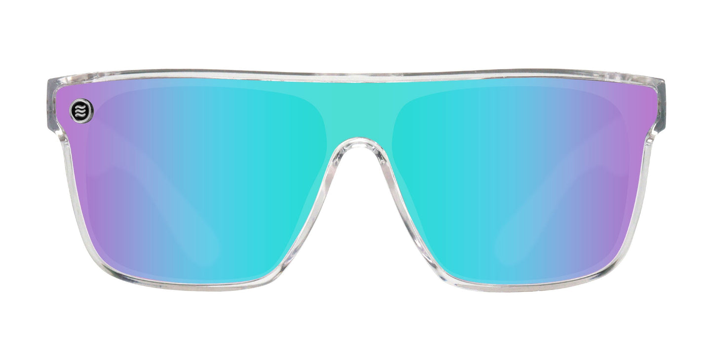 Part of Neven Eyewear’s Legend collection, the Fidelity sunglasses feature a clear frame, large single-piece mirrored lenses with UV400 protection that fade from aqua blue to purple, and a small circular logo at the top left corner.