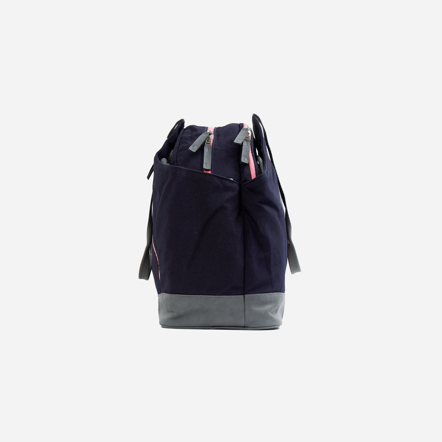 The Doubletake LONDON Pickleball Duffel & Tote in navy blue features a light gray rectangular base and handles, a top zipper with a pink accent, and gathered fabric, offering ample storage, shown upright from the side against a white background.