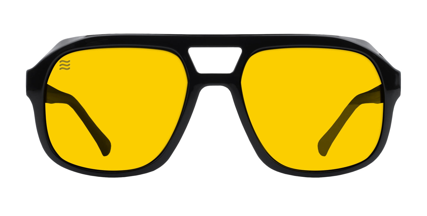 The Neven Eyewear Helios sunglasses feature black aviator frames with UV400 protection and bright yellow lenses. They have a double bridge design, visible arms through the lenses, and a wavy detail on the top left of the left lens.