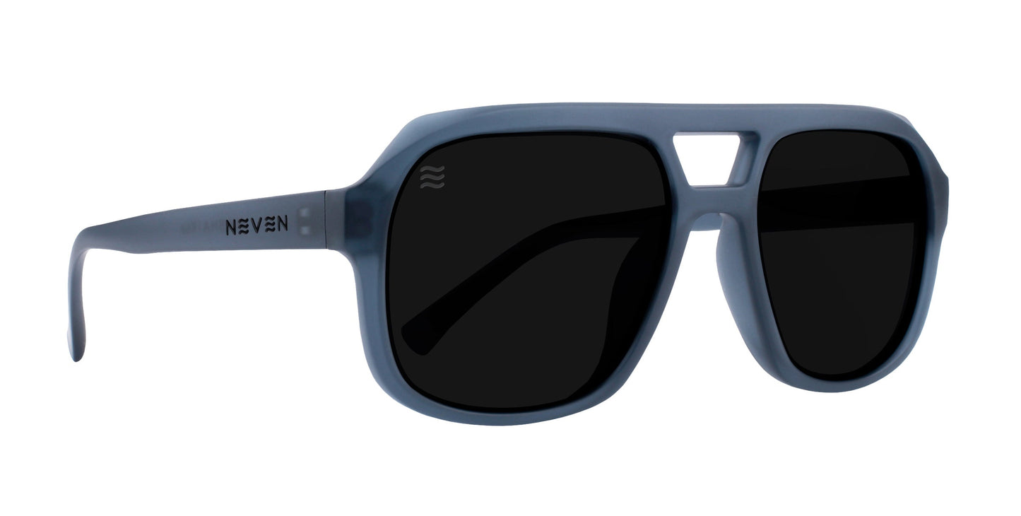 The Koa by Neven Eyewear features matte blue-gray aviator frames with a double bridge, thick angular design, polarized UV400 lenses, “NEVEN” on the left arm, and a signature wave logo on the upper left lens.