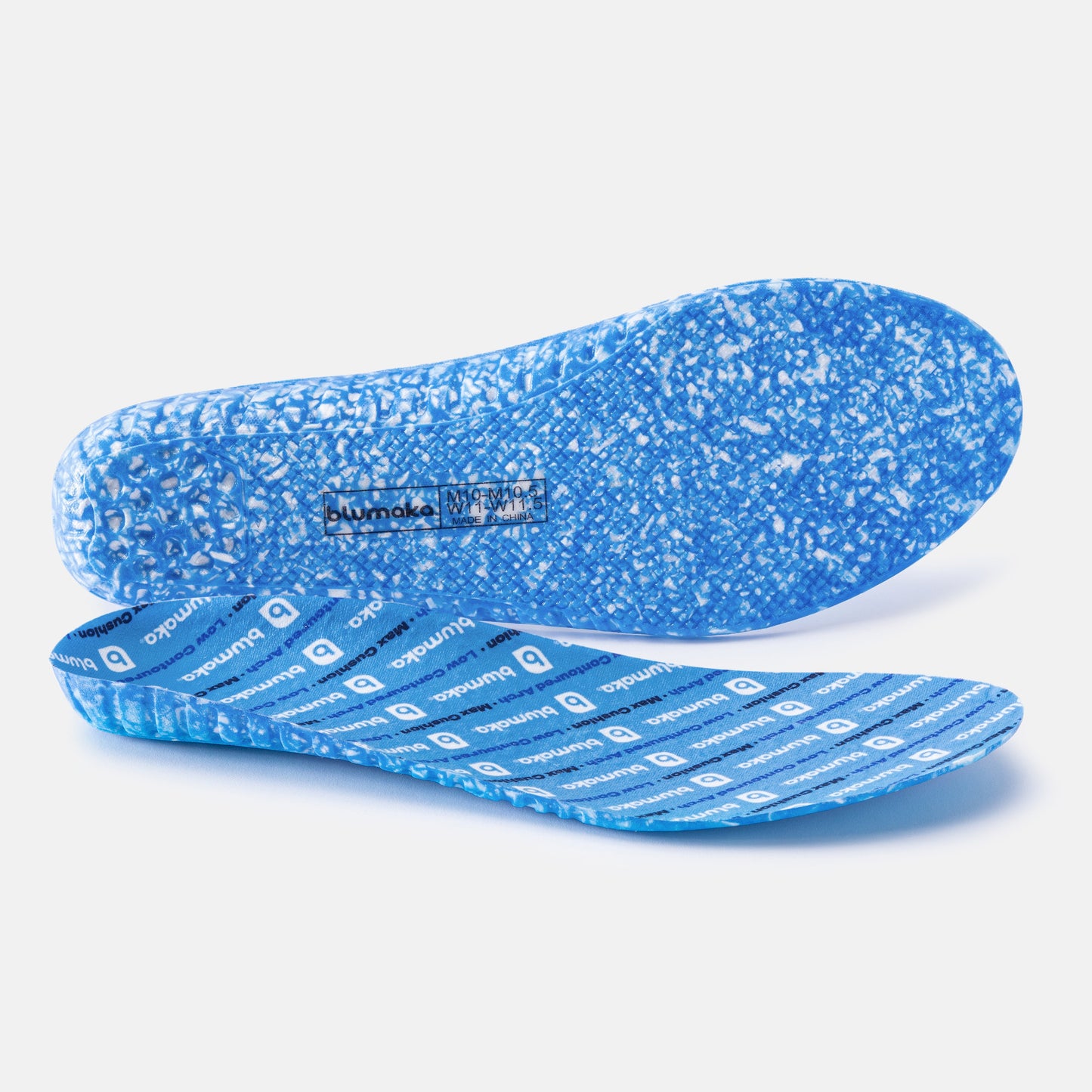 Two blue Blumaka Comfort Insoles are displayed: one lies flat, showing a textured blue and white speckled underside; the other is angled to reveal a blue top with repeating "Blumaka" logos and lines for enhanced shock absorption. The background is plain white.