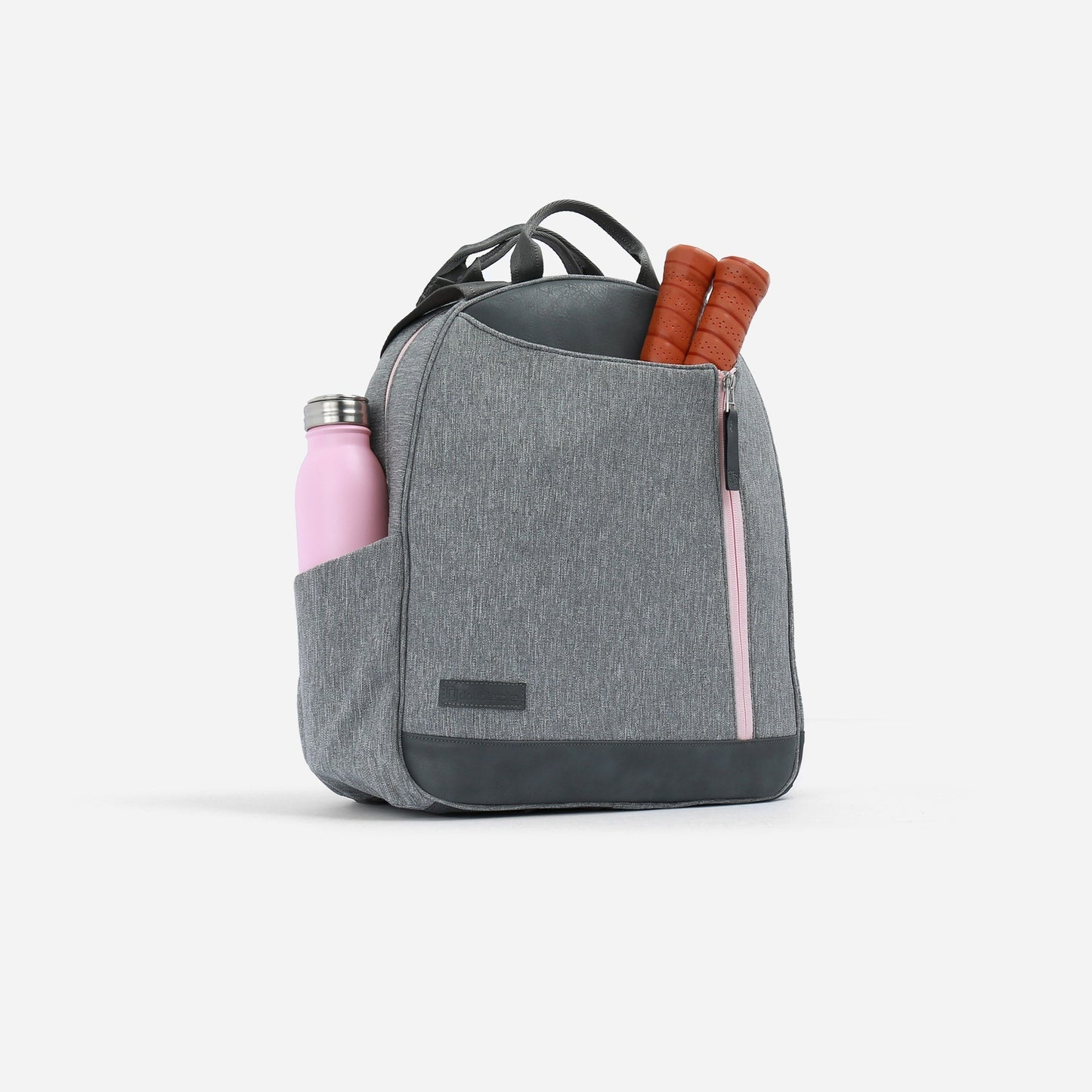 The Doubletake MELBIE Pickleball Backpack & Tote is shown in light gray with a black base and pink zipper. Designed for versatility, it holds two rackets and a pink water bottle, features water-resistant fabric, and sits against a white background.
