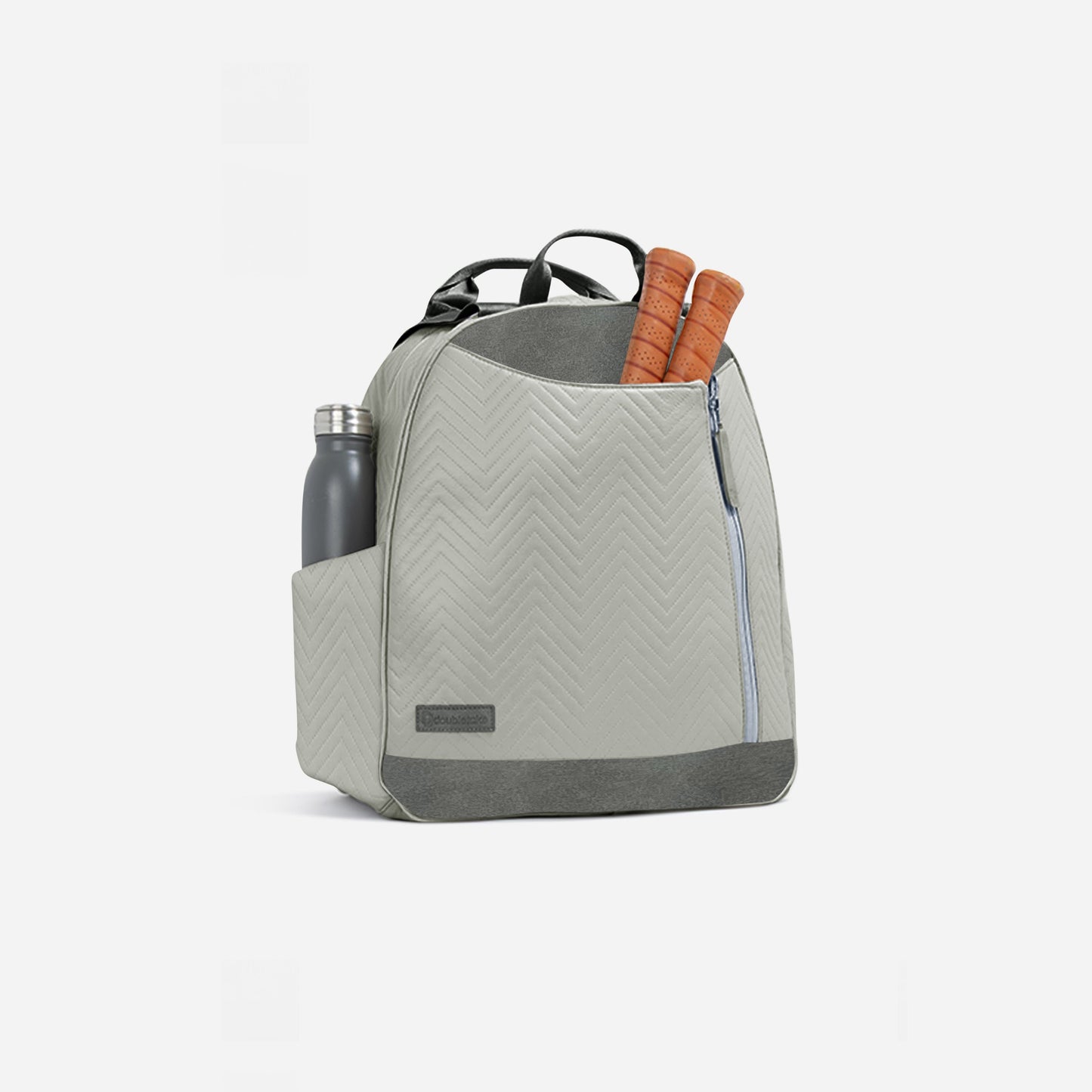 The MELBIE | Pickleball Backpack & Tote by Doubletake is shown in light gray chevron, with a front zipper pocket, two brown-handled tennis rackets sticking out the top, and a stainless steel water bottle in the left side pocket. Plain white background.