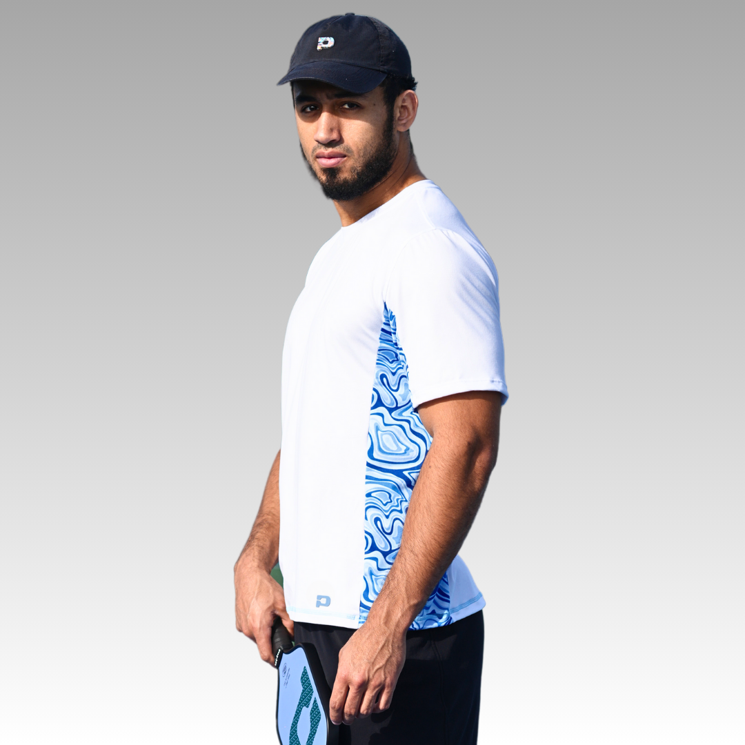 A man in a hat wears the Playly Store Warrior Tee 2.0, a moisture-wicking shirt ideal for keeping cool during any activity.