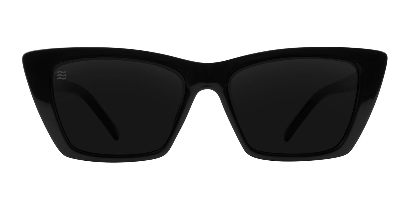 The Noir cat-eye sunglasses by Neven Eyewear feature thick, glossy black frames, dark polarized UV400 lenses, and a subtle logo. Photographed from the front, they exude French elegance with both style and reliable protection.