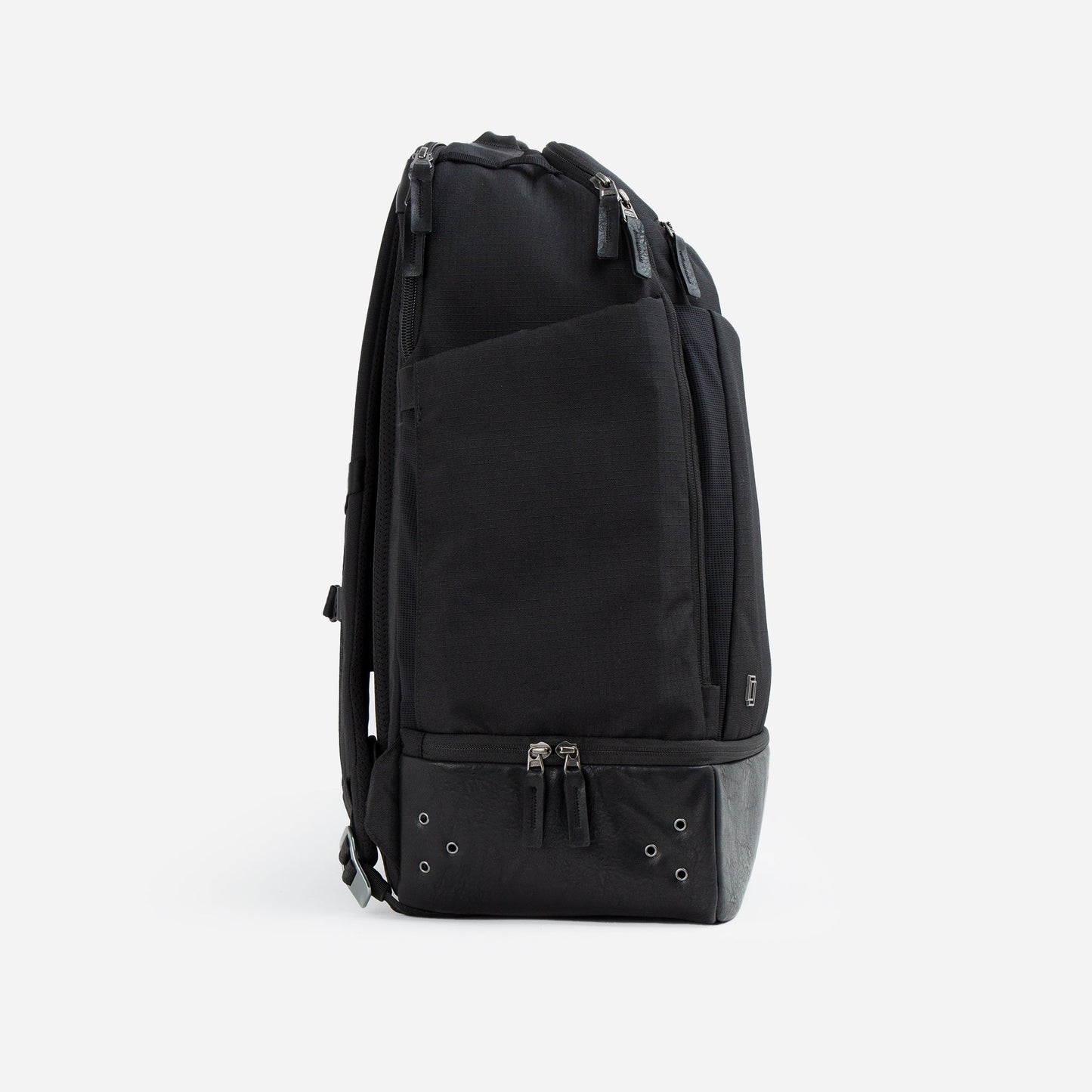 The Doubletake NYC Pickleball Backpack is a sleek, modern black bag shown upright from the side, featuring zippered paddle compartments, padded shoulder straps, and a structured base with metal eyelets—all on a white background.