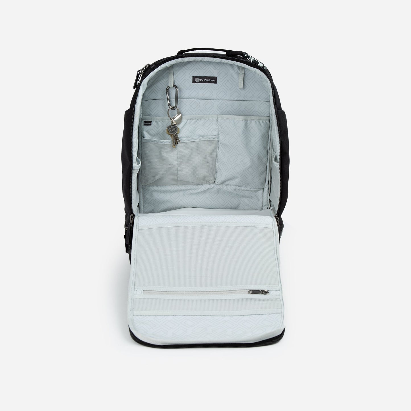 The Doubletake NYC Pickleball Backpack in black and light gray is open, revealing an organized interior with multiple gear pockets, a key holder with keys, and a zippered mesh compartment on the front flap against a subtle patterned lining.
