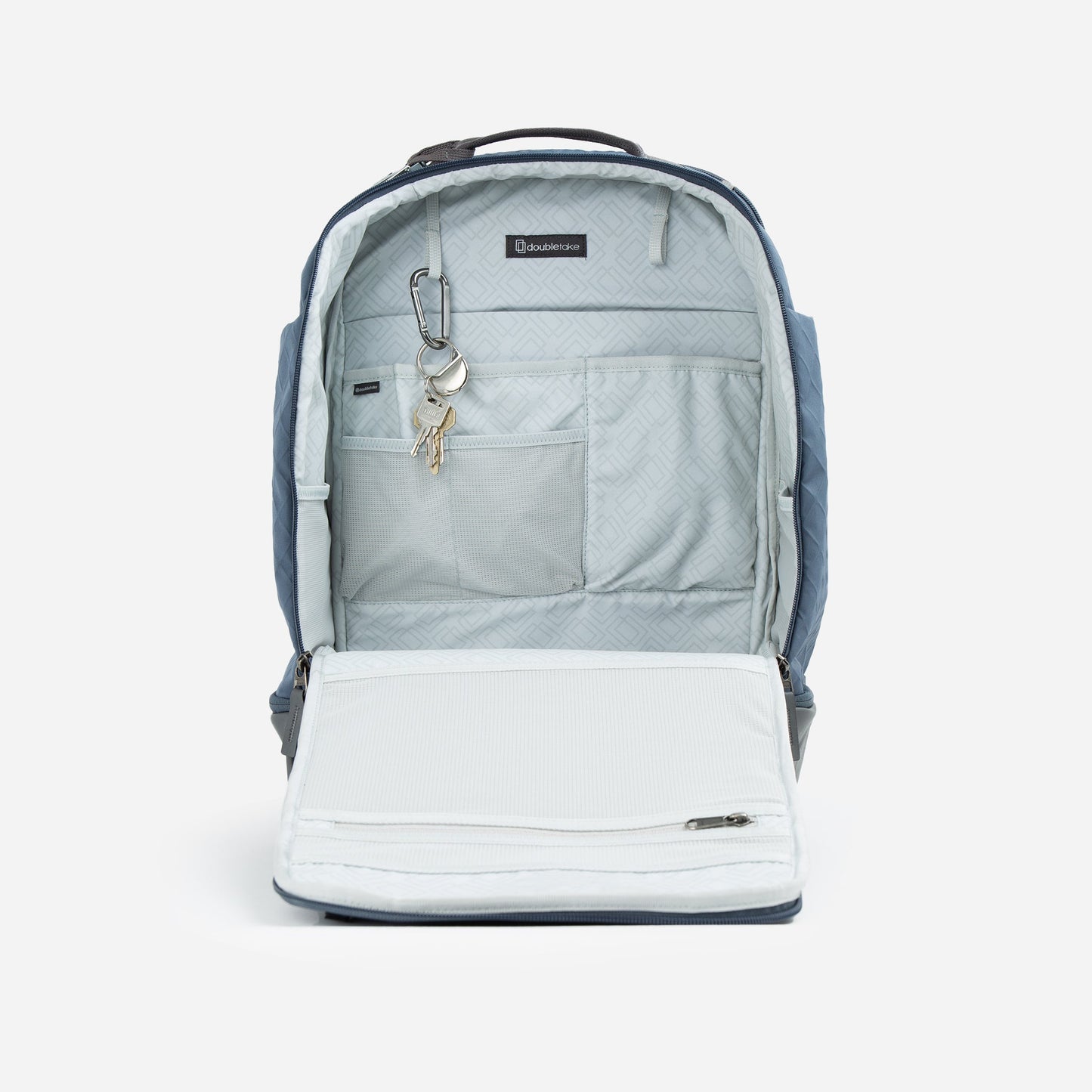 The Doubletake NYC Pickleball Backpack, shown in blue, is open to reveal its light gray patterned interior with several pockets, a zippered mesh compartment on the flap, and a key leash holding two keys attached to a silver clip.