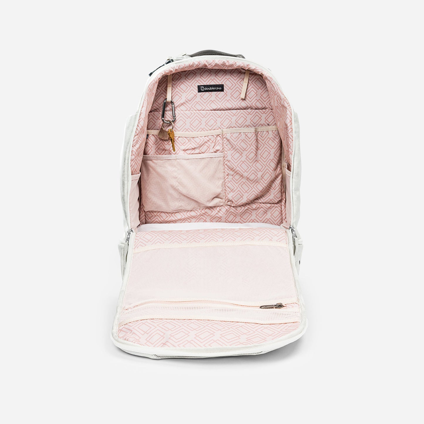 The NYC Pickleball Backpack by Doubletake is shown fully unzipped, displaying a pink diamond-patterned interior with multiple gear pockets, a key clip with key, and an interior zippered compartment on the flap.
