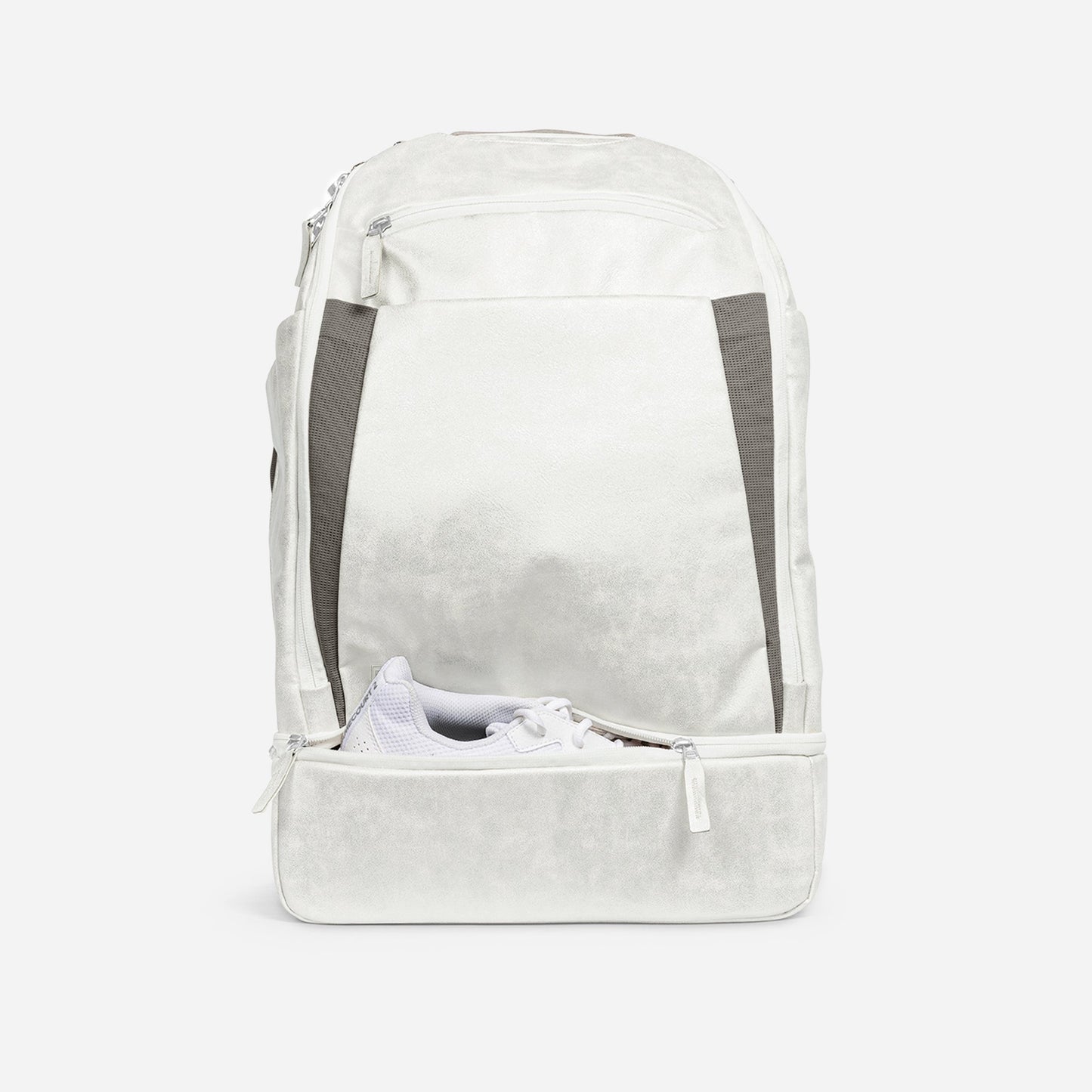 The Doubletake NYC Pickleball Backpack is shown in white with gray accents and silver zippers, its large front compartment unzipped to reveal a white athletic shoe. Ideal for carrying your pickleball gear. Displayed on a plain white background.