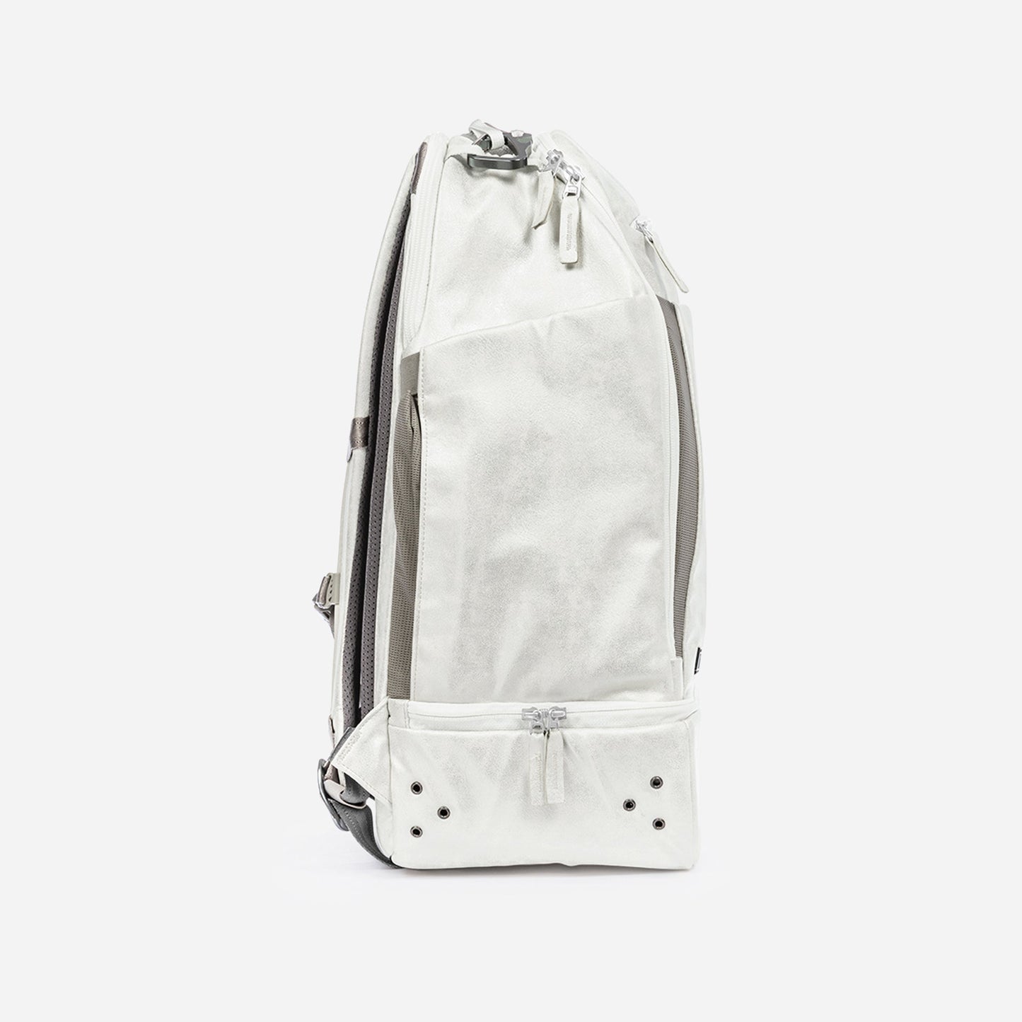 The Doubletake NYC Pickleball Backpack stands upright on a white background, showcasing its slim, modern profile, white color with grey accents, black ventilation holes, and multiple zippered compartments for pickleball gear.