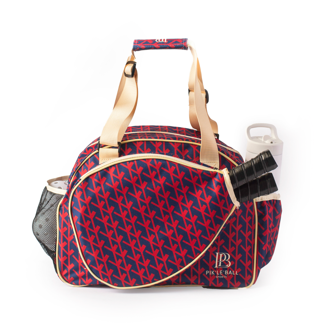 The Court Couture Navy Premium Women's Pickleball Bag by Pik'le'Ball Sports features a stylish geometric design, beige handles, side pockets with three black paddles, a mesh compartment for your water bottle, and "Pickleball" labeled near the bottom.