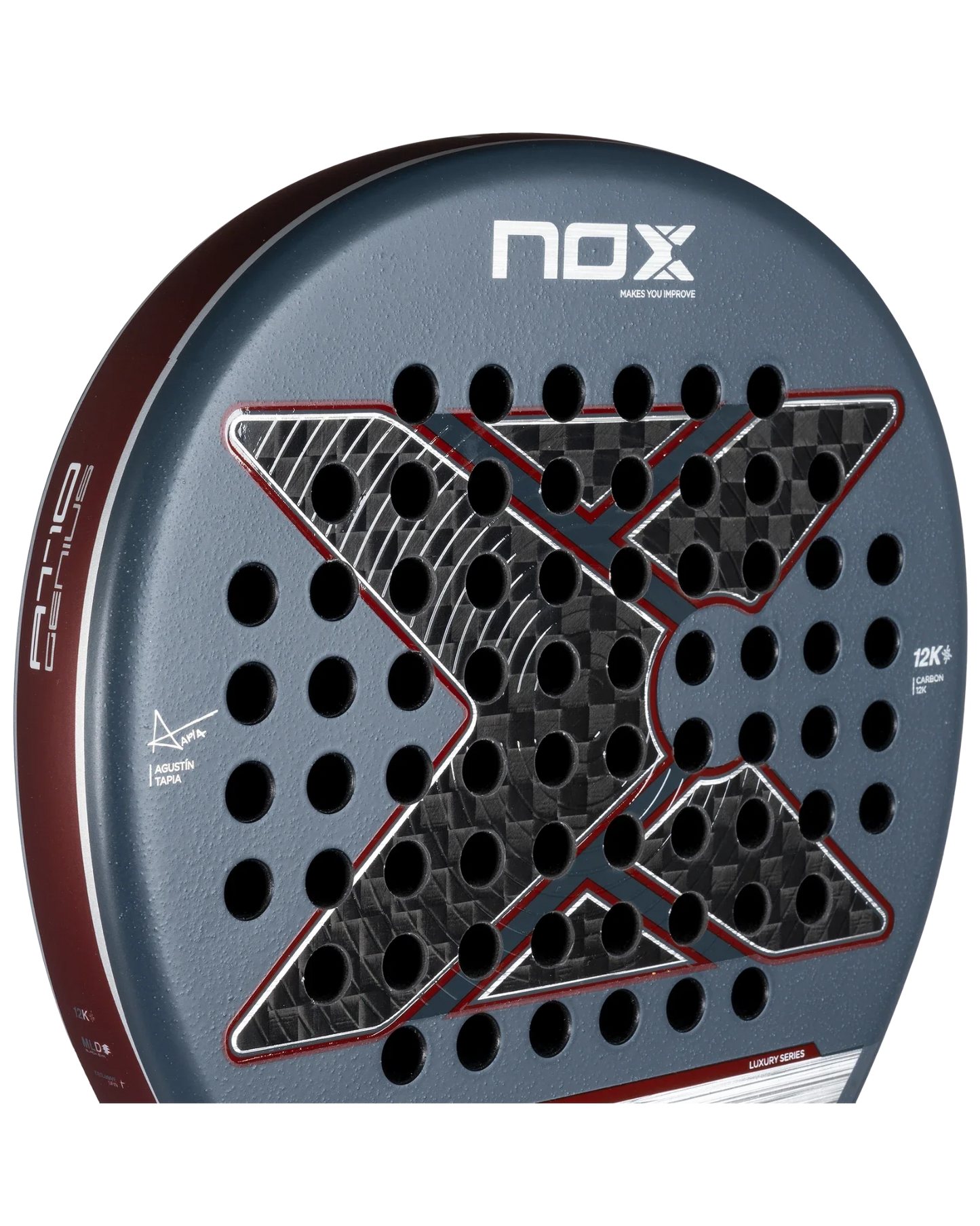 Close-up of the Nox AT10 Luxury GENIUS 12K 2025 by Agustin Tapia from Padel USA, showing a large black X graphic, multiple circular holes, textured gray and red surface, durable 12K carbon fiber build, and white branding on face and side.